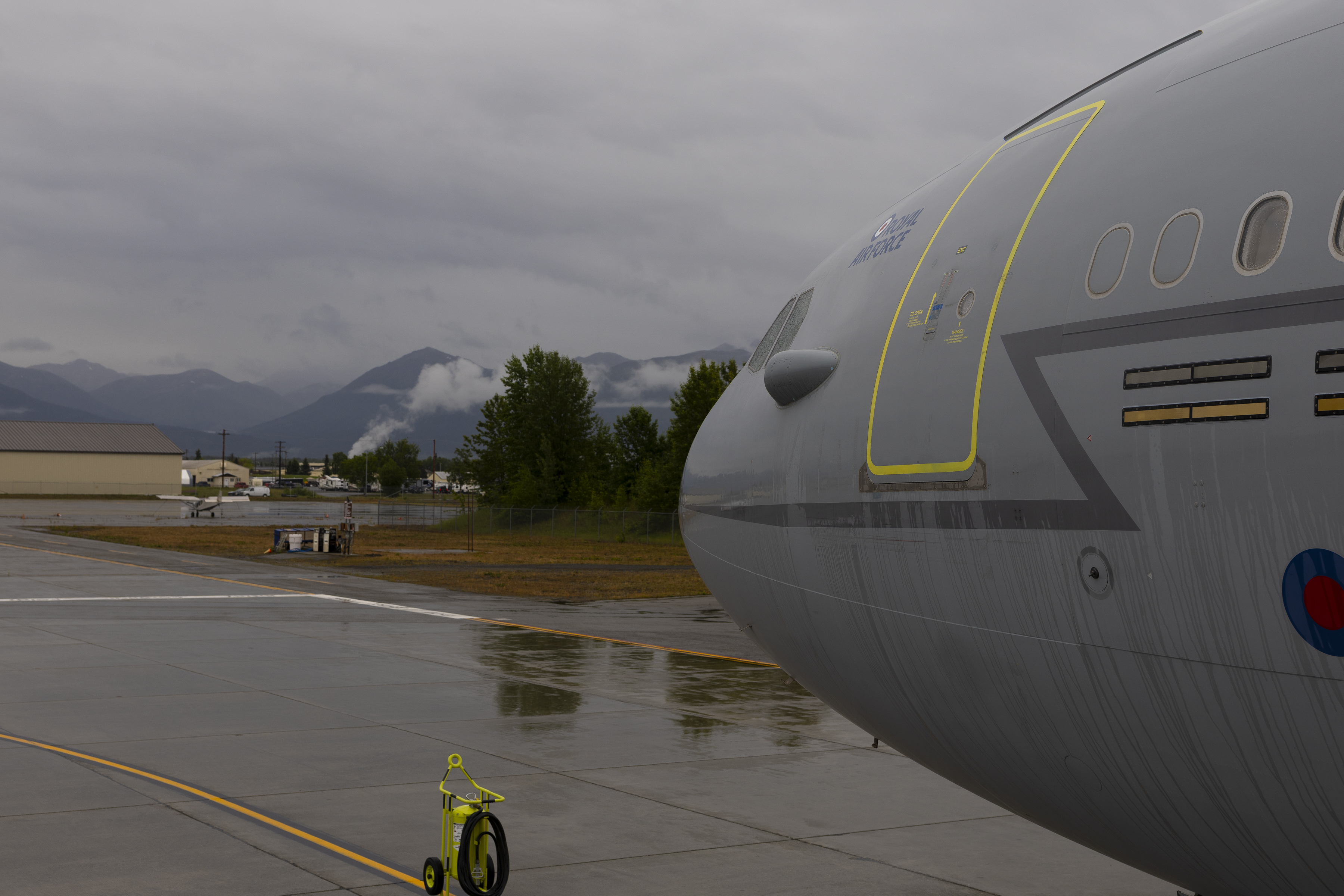 An RAF Voyager aircraft on the ground with landscape in the background.