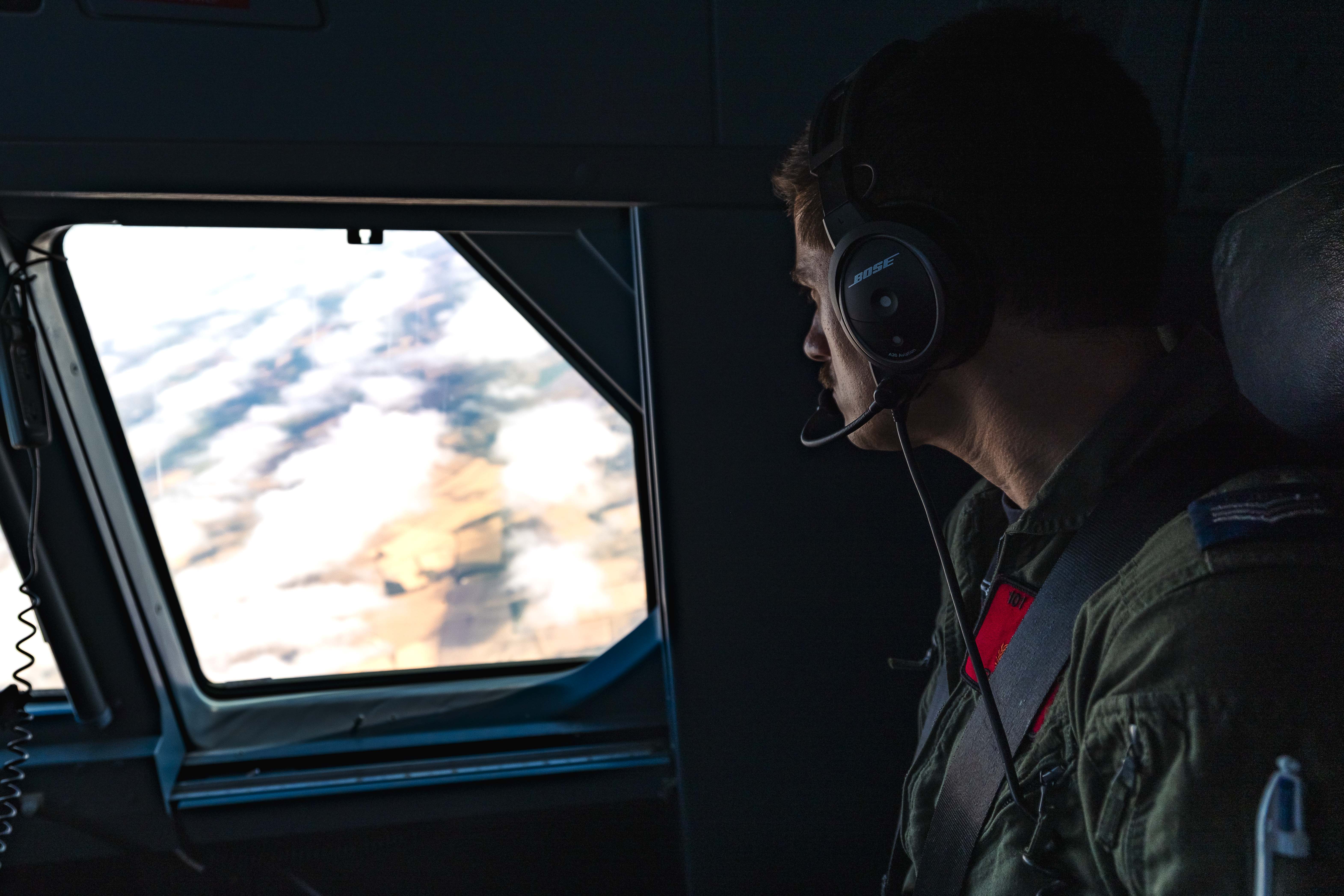An RAF serviceperson looking out of the window of an RAF aircraft during Exercise Combat Archer.