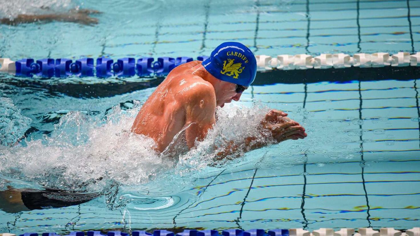 Corporal Kyle mid-race. He is wearing a swimming cap with "Cardiff" written on it.