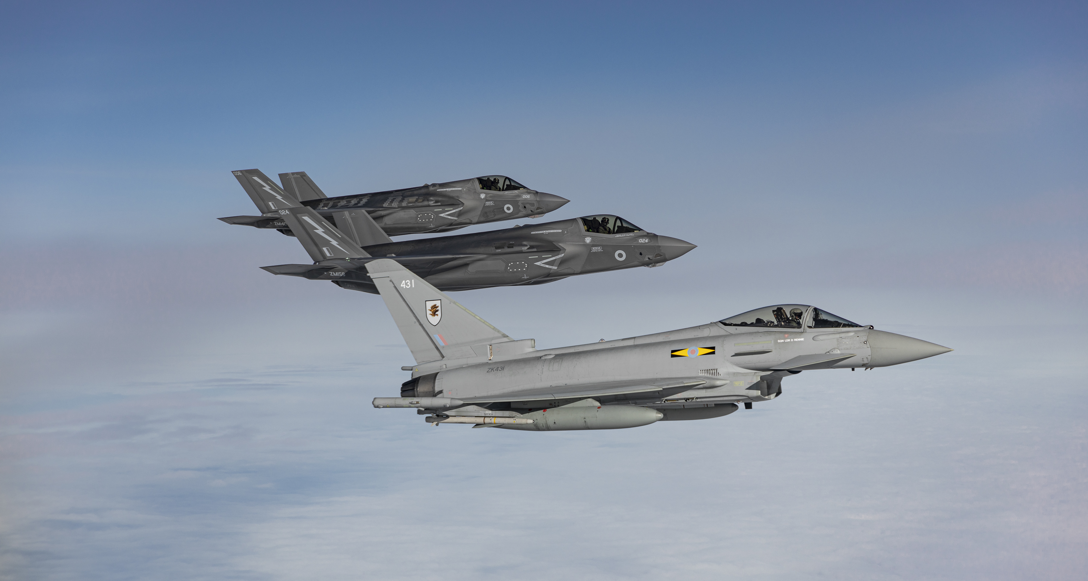 Three aircraft in flight through blue skies