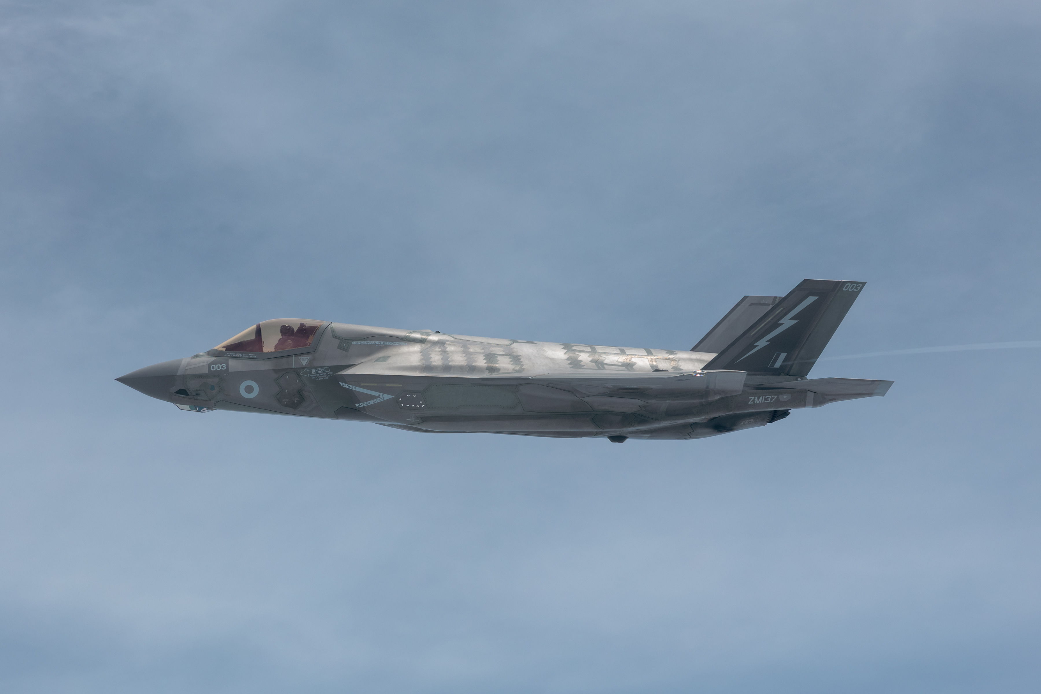 An F-35 Flys solo against a blue sky