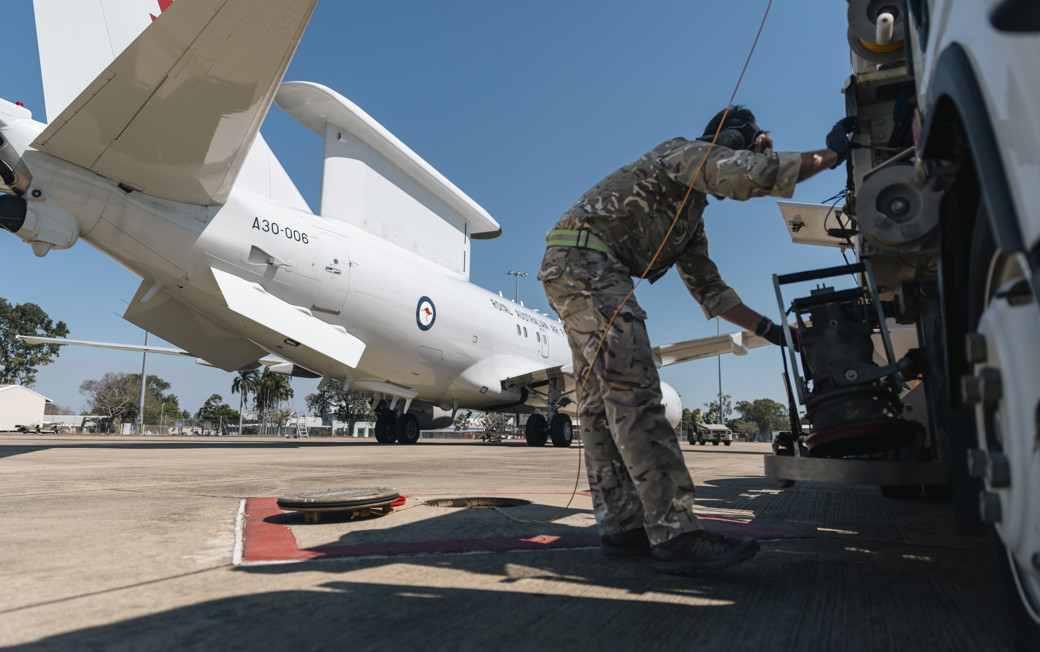 A refueller at work, with an aircraft of the Royal Australian Air Force visible in the background.
