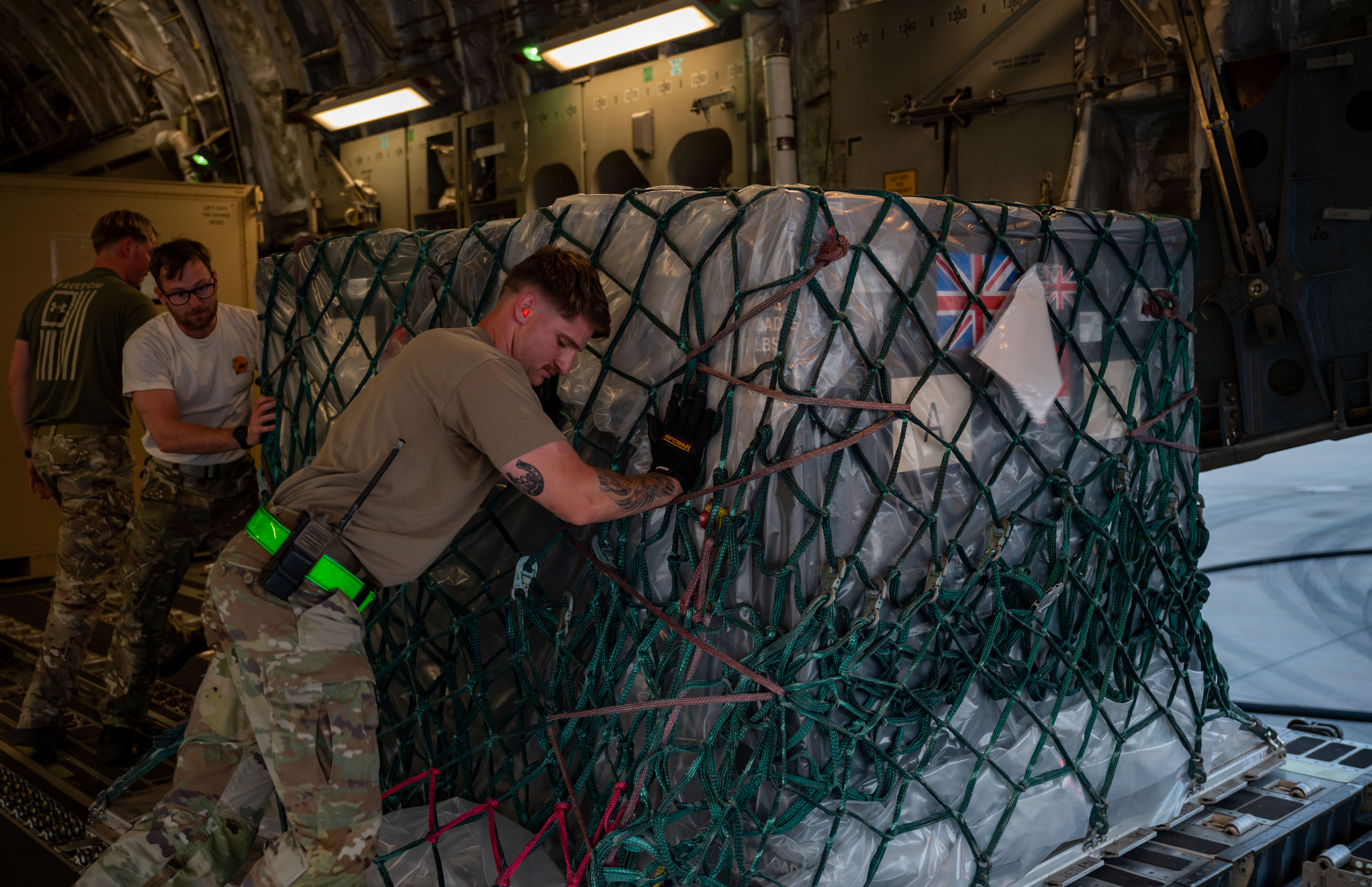 US Airmen and Royal Air Force Service Personnel offload cargo from a C-17 Globemaster III assigned to 99 Squadron, Royal Air Force Brize Norton within the U.S. Central Command area of responsibility, April 12, 2025. (U.S. Air Force photo by Senior Airman Amanda Jett)