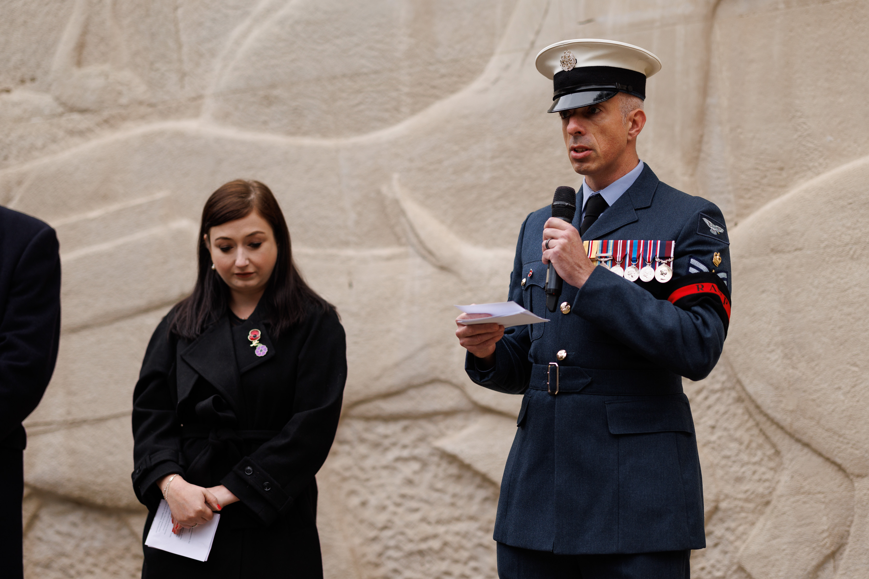 Flight Sergeant Ginger in RAF uniform speaking into a microphone.