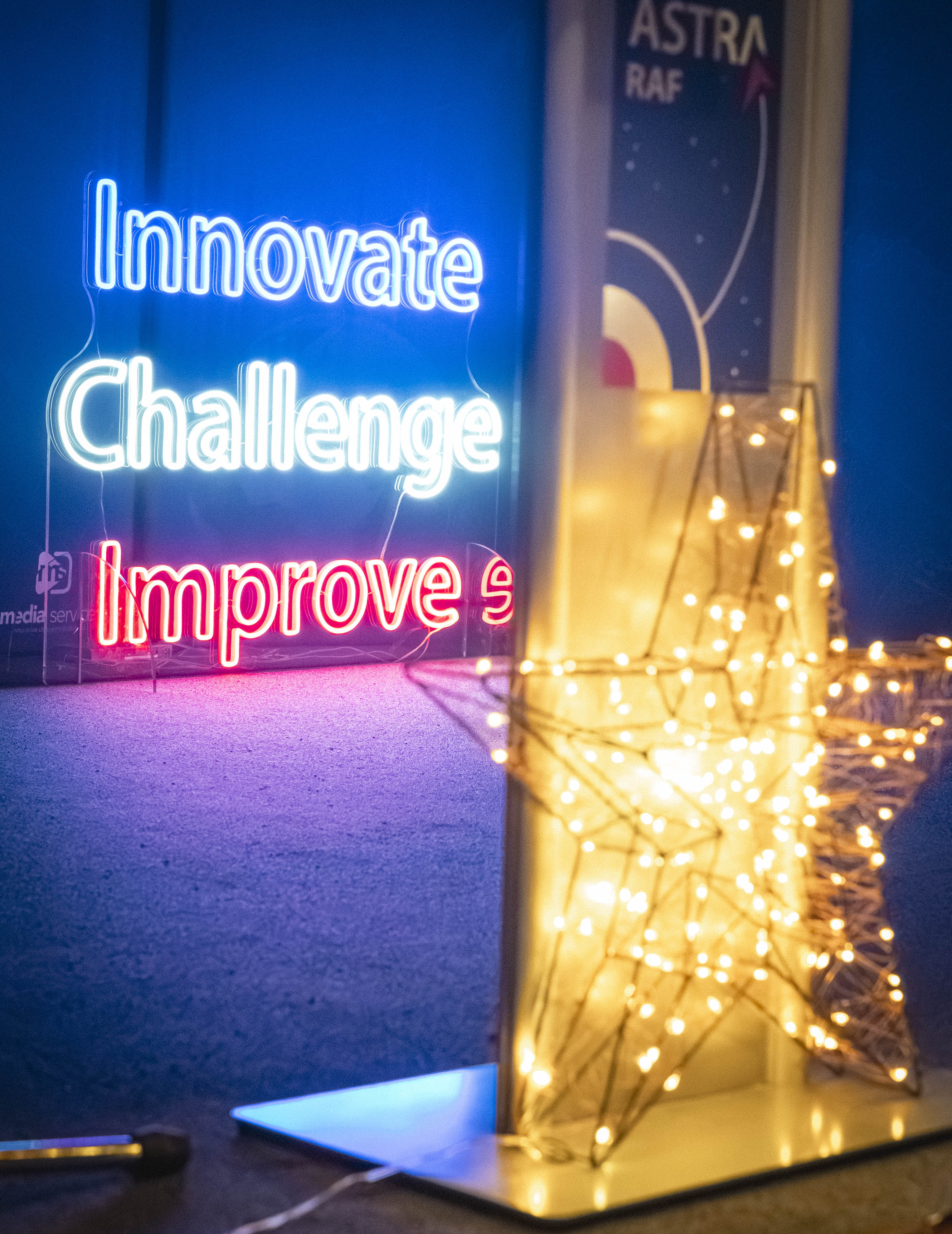 The stage showing a shining star and an innovate, challenge, improve neon sign