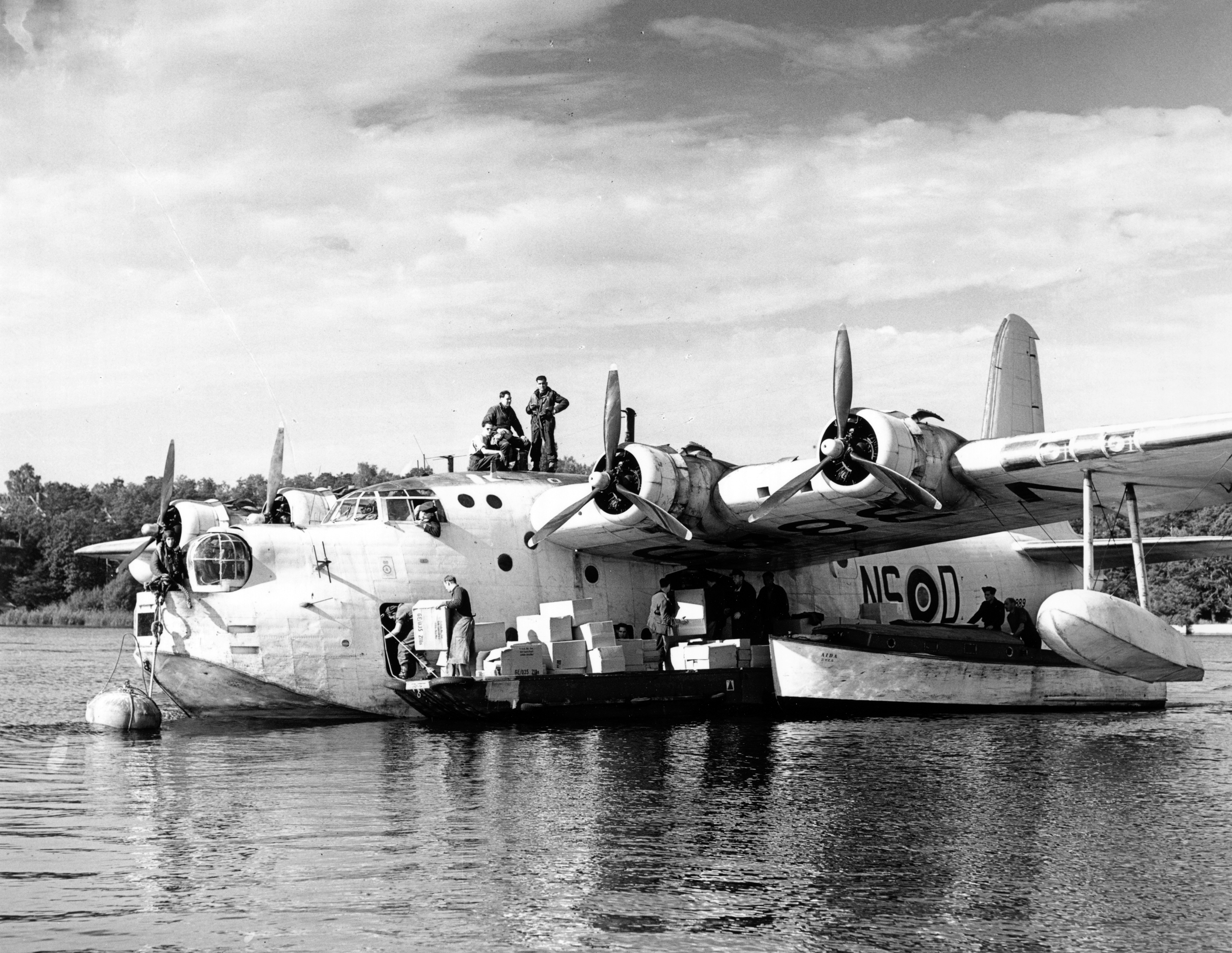 Image shows an RAF Sunderland on water delivering aid.