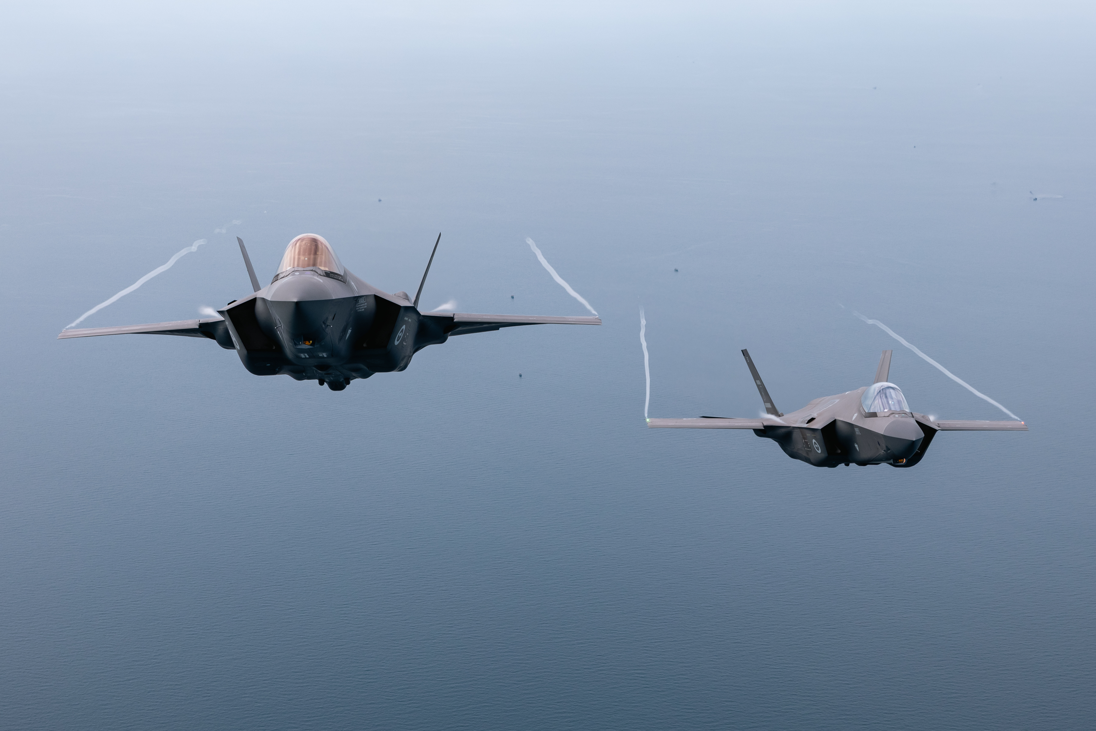 Two Royal Australian Air Force F-35As on a joint sortie with Royal Air Force A400M training off the coast of Malaysia. Photo taken with the A400M ramp down.