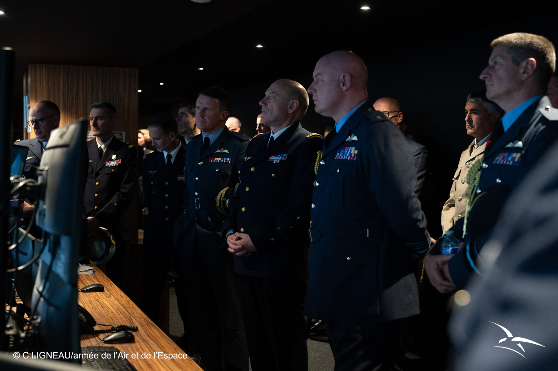 A photo of senior British and French Air Force officers as they watch observe something on a screen together.