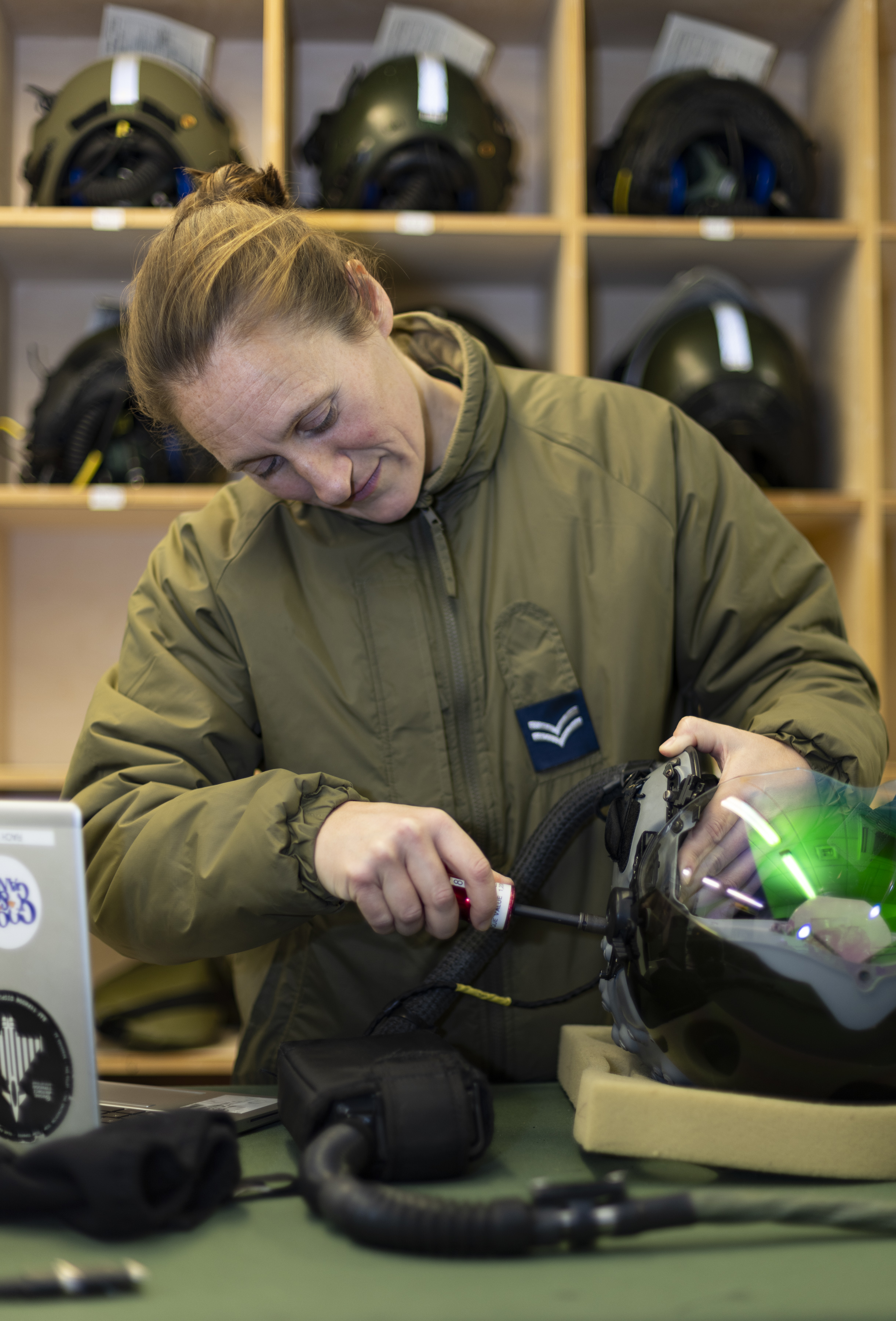 Personnel handles helmet and tools.