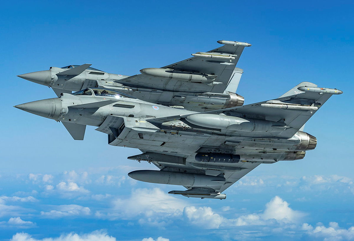Two Royal Air Force Typhoons in the midst of a dramatic formation break, showcasing the agility and speed of these frontline combat aircraft.