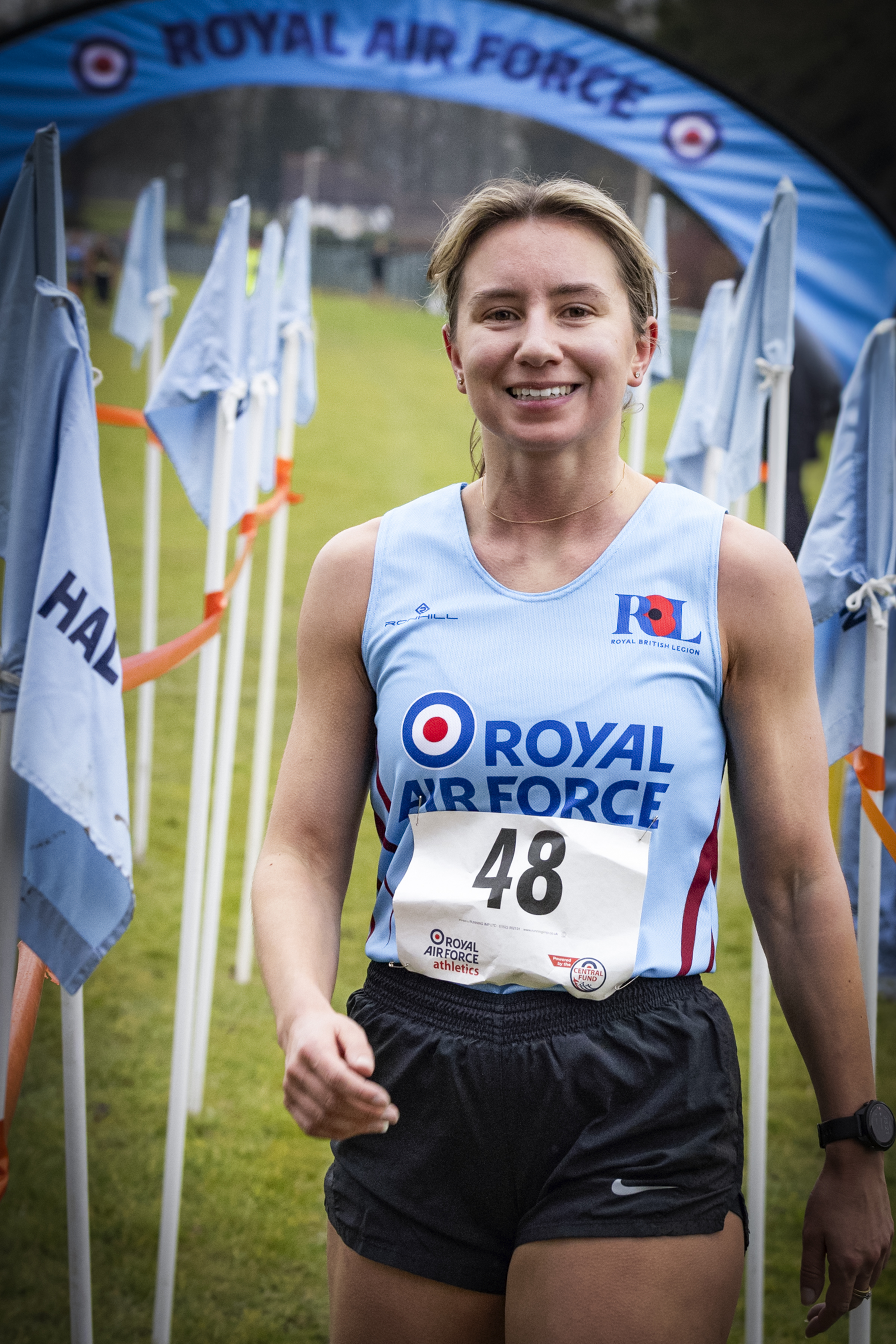 An RAF runner in RAF colours comes through the finish line