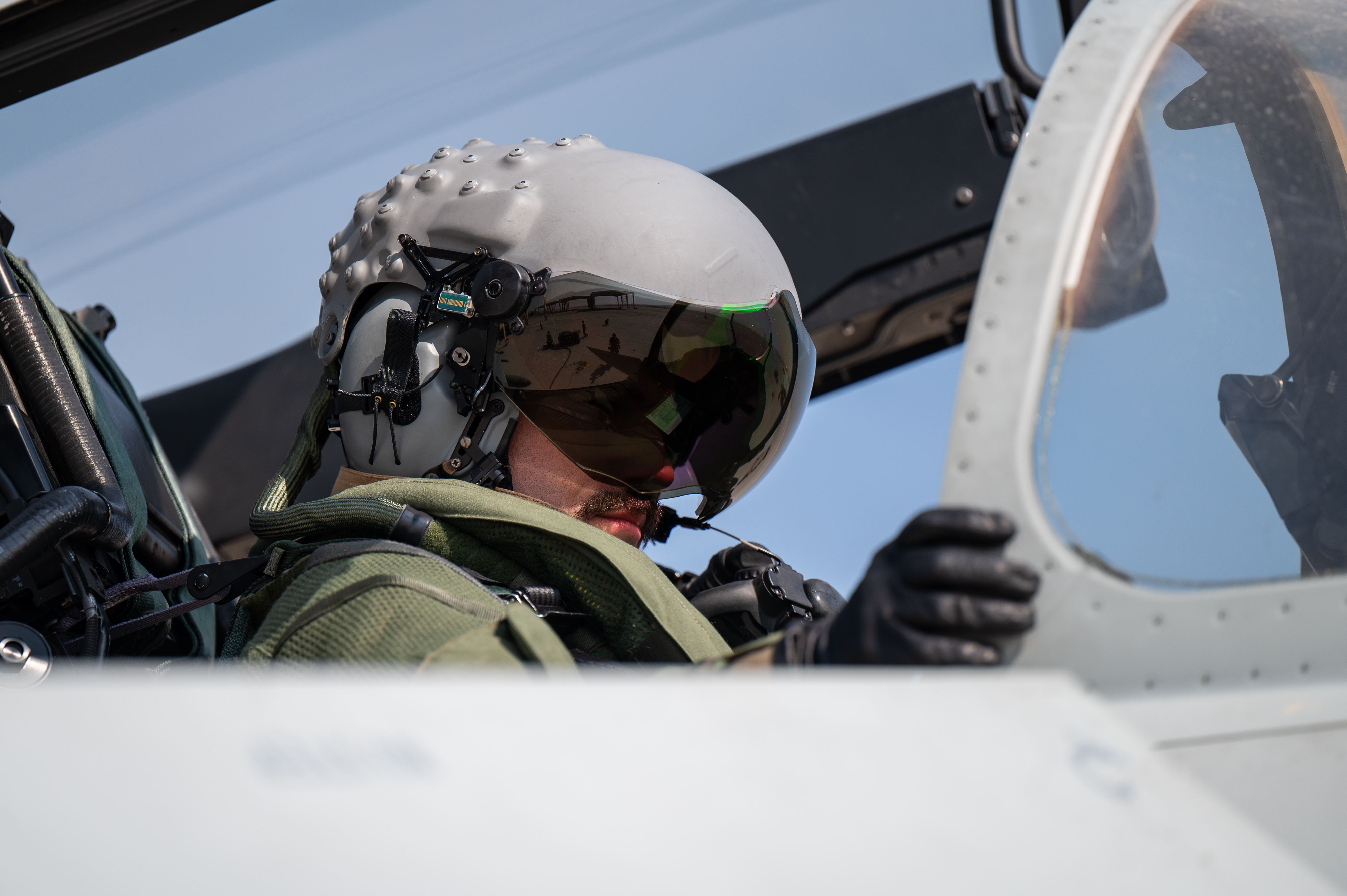 An RAF pilot in the cockpit of a Typhoon, wearing a Strike II helmet.