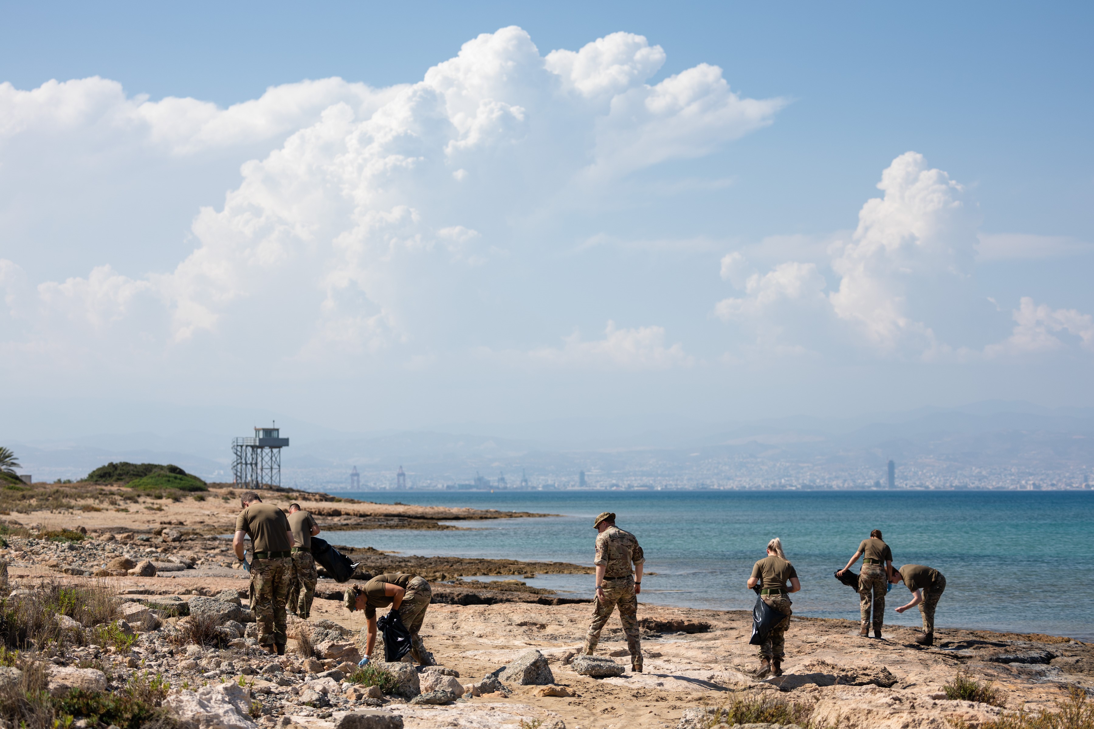 Cleaning on the beach with the sea in the background, image taken from further back.