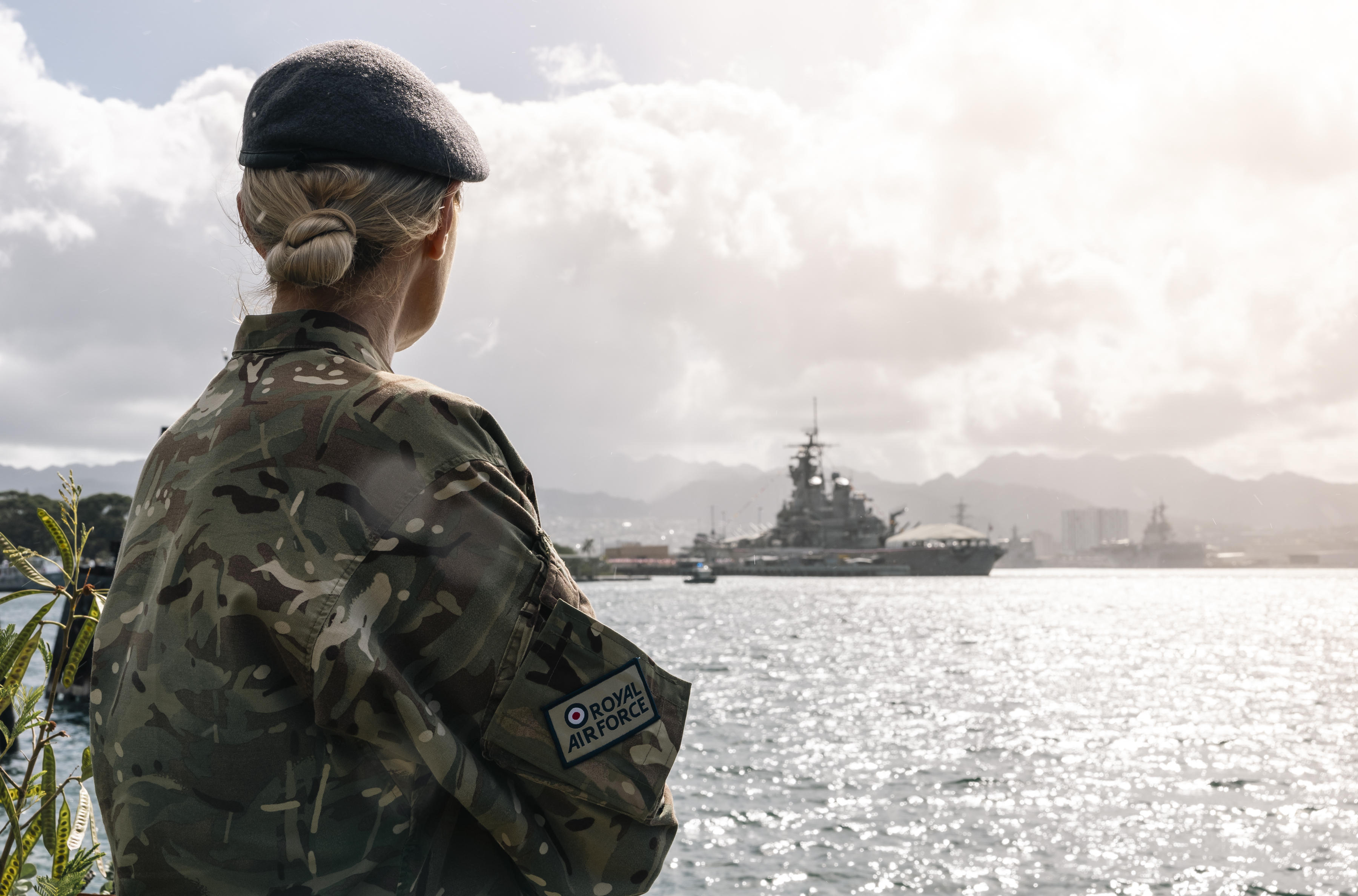 Behind view of an RAF service person on the shore at Ford Island, Pearl Harbor.