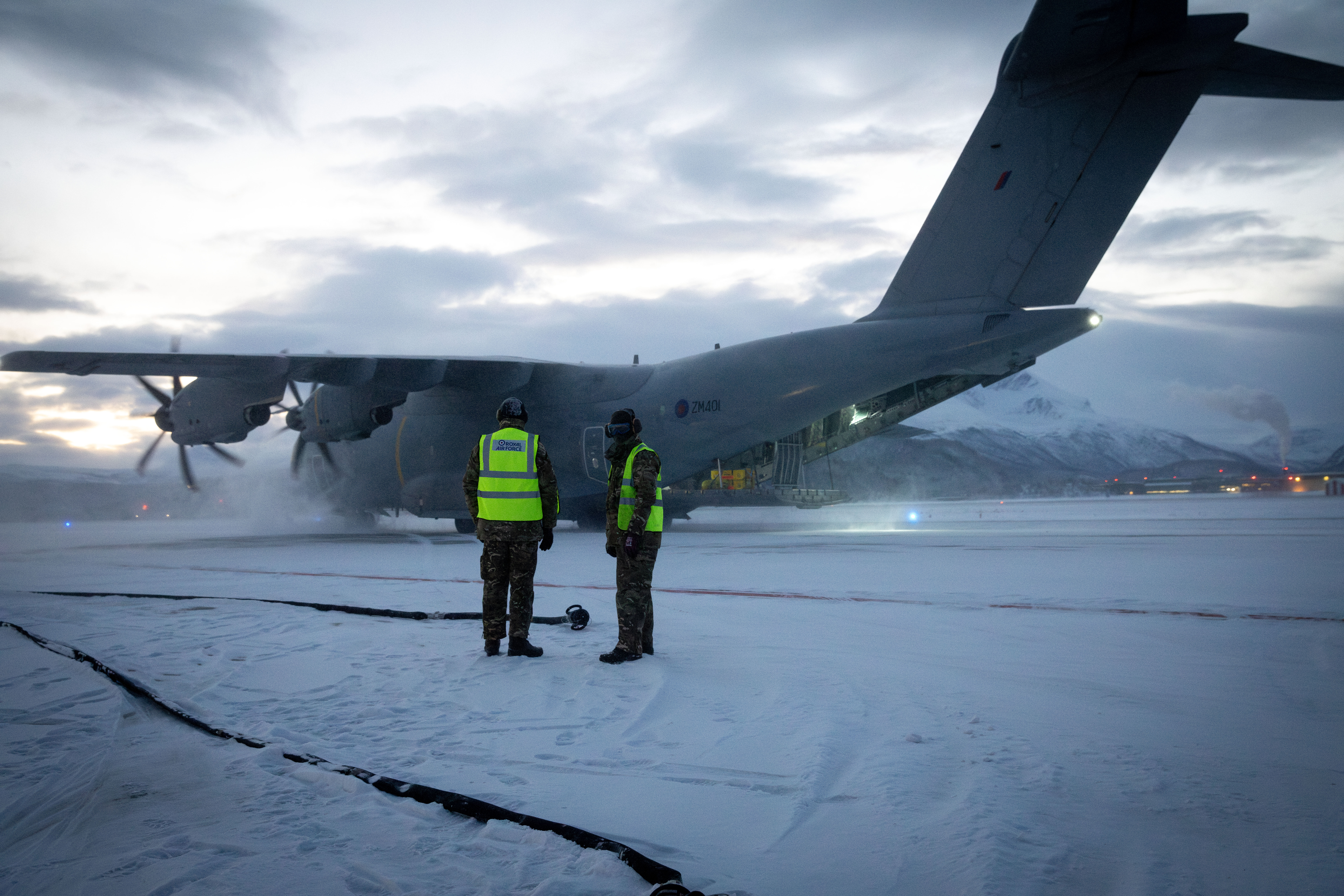 Two personnel in front of an Atlas A400 in the snow