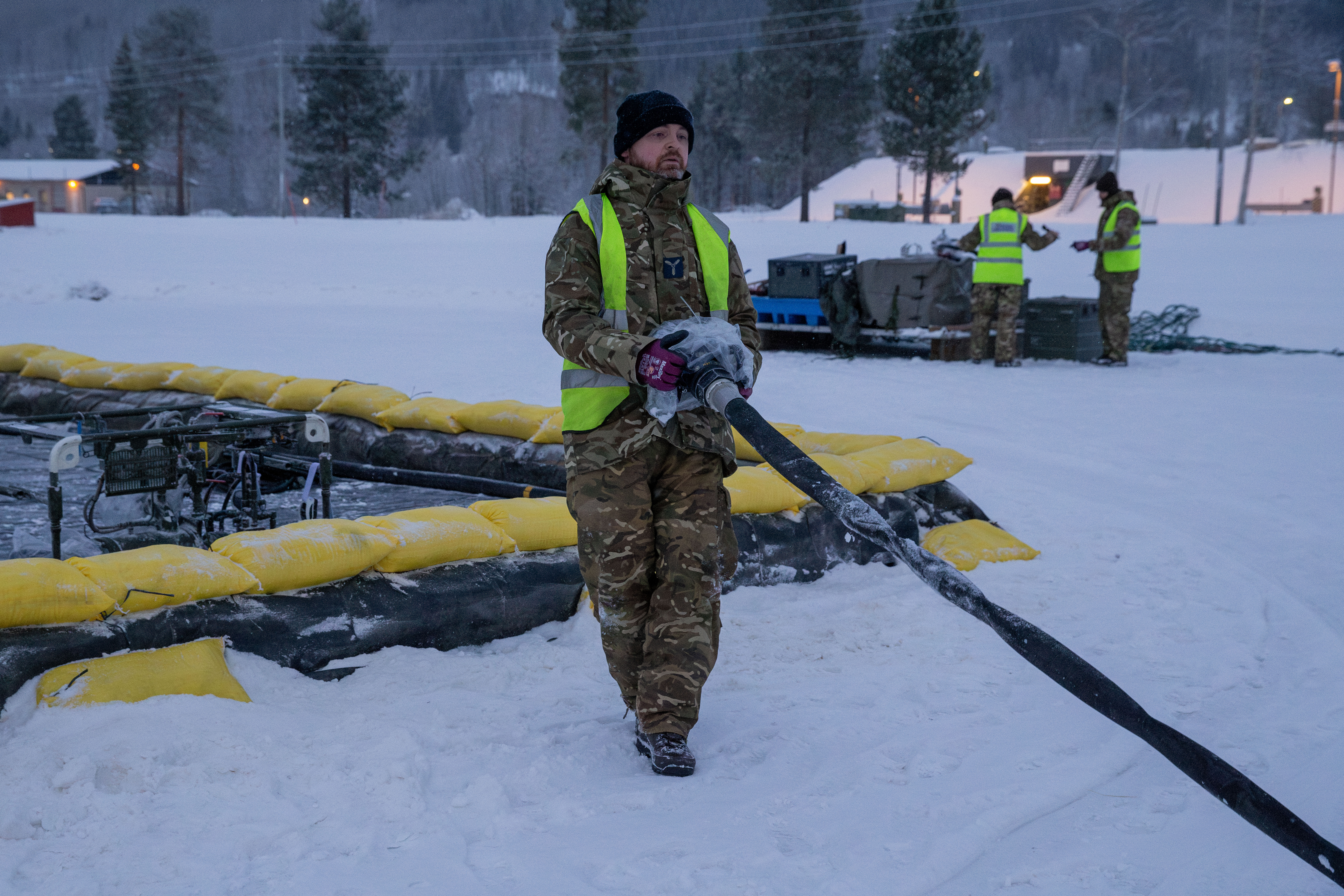Serviceperson testing equipment in the snow.