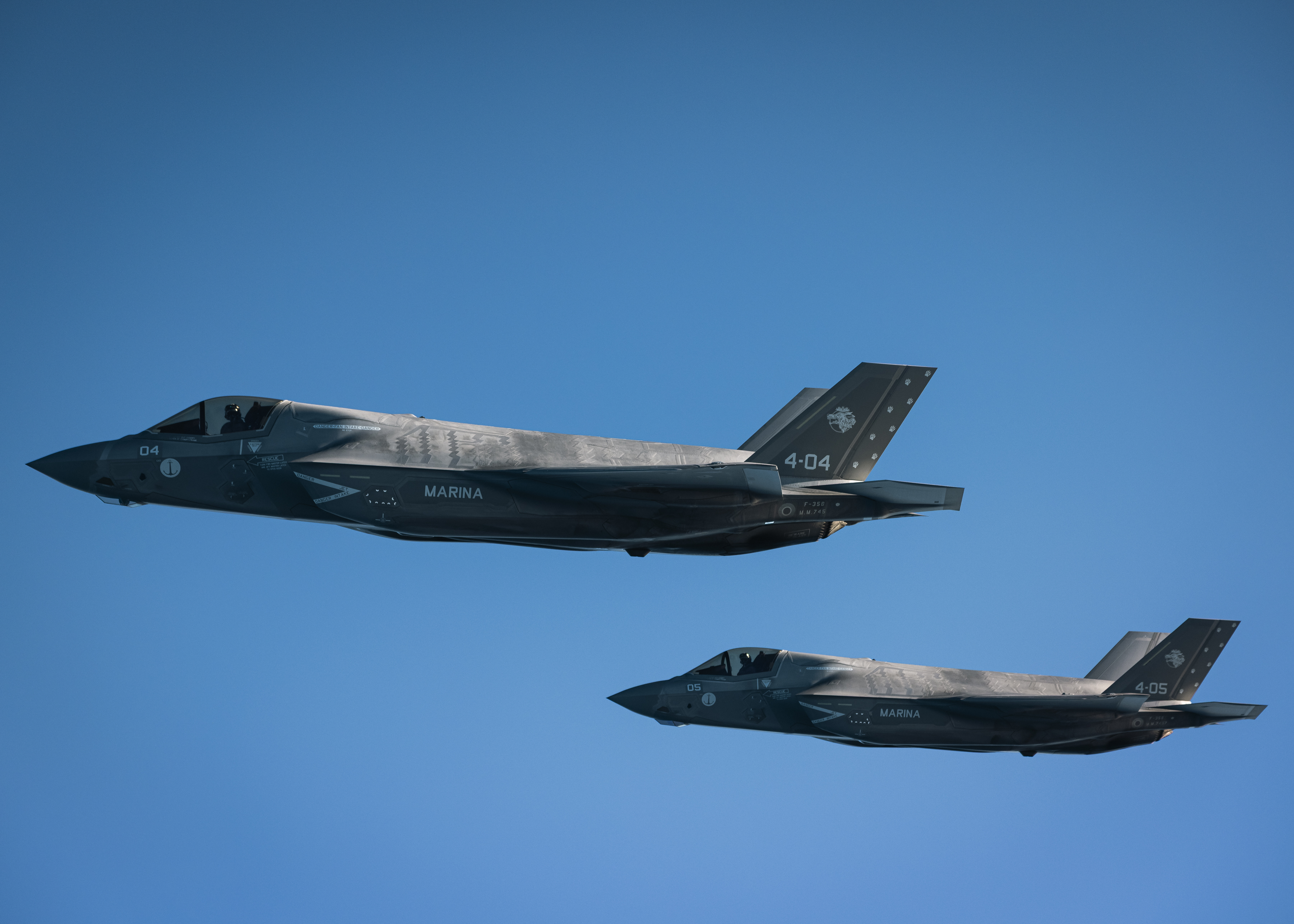 Two F-35 fighters flying in formation.