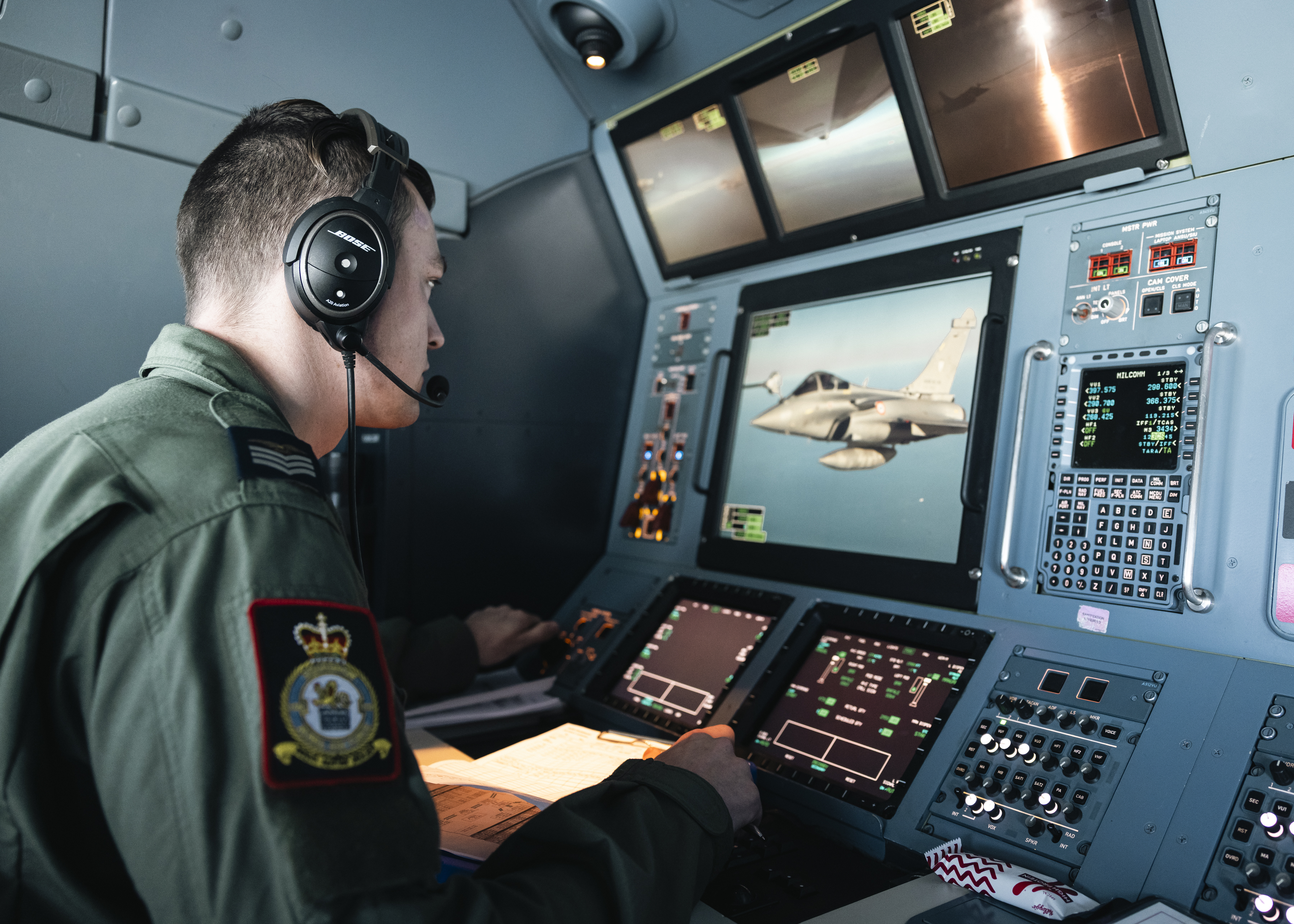 A crew member looking at a screen onboard an aircraft.