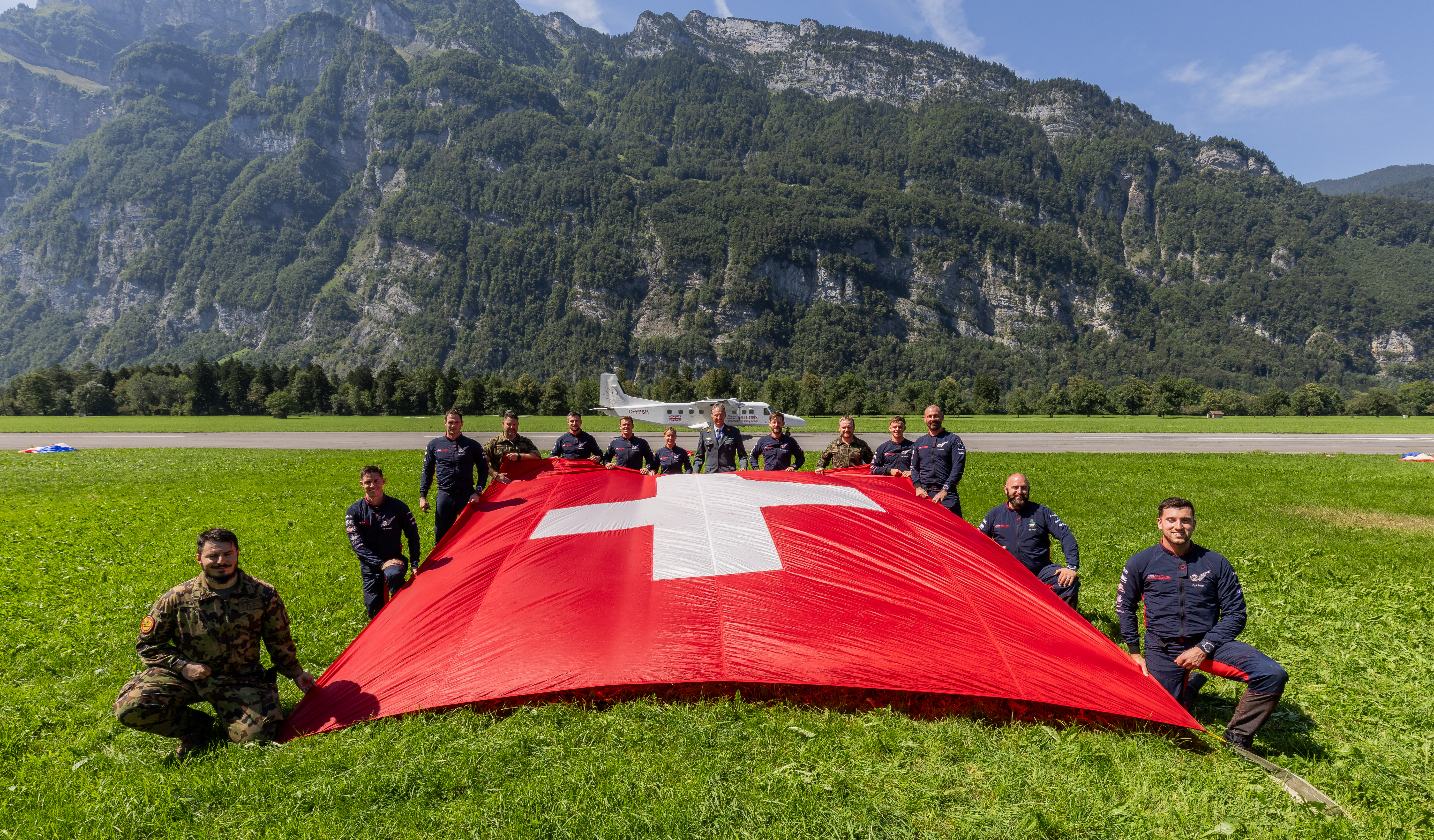 RAF Falcons and Swiss Parawings holding out the Swiss flag against the mountainous backdrop
