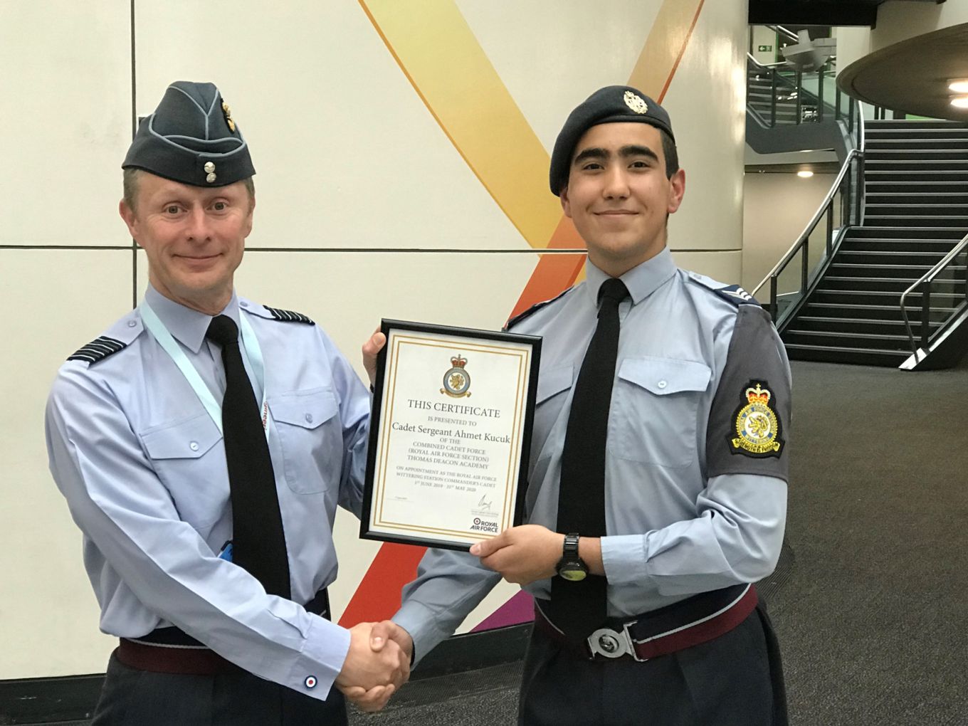 Group Captain Tony Keeling presents Cadet Sergeant Ahmet Kucuk with his certificate