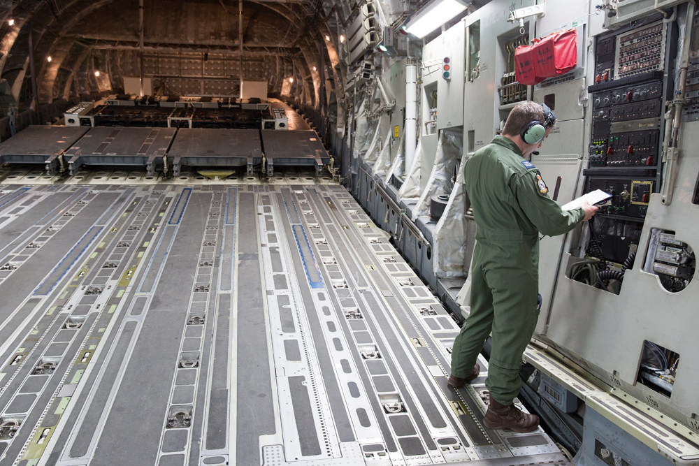 Inside the C-17, a Weapons Systems Operator checks his data.