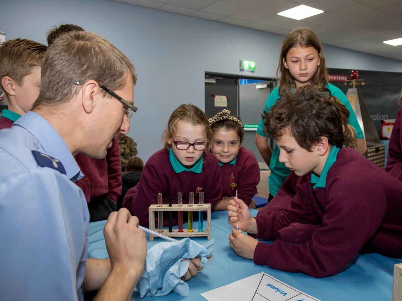 An RAF serviceman explains to children how a thermometer works