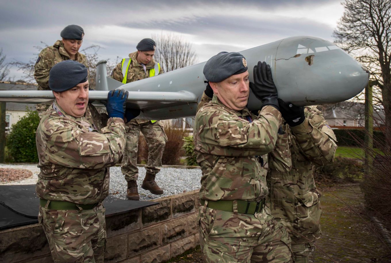Personnel carefully carrying the Nimrod Model towards the low-loader.