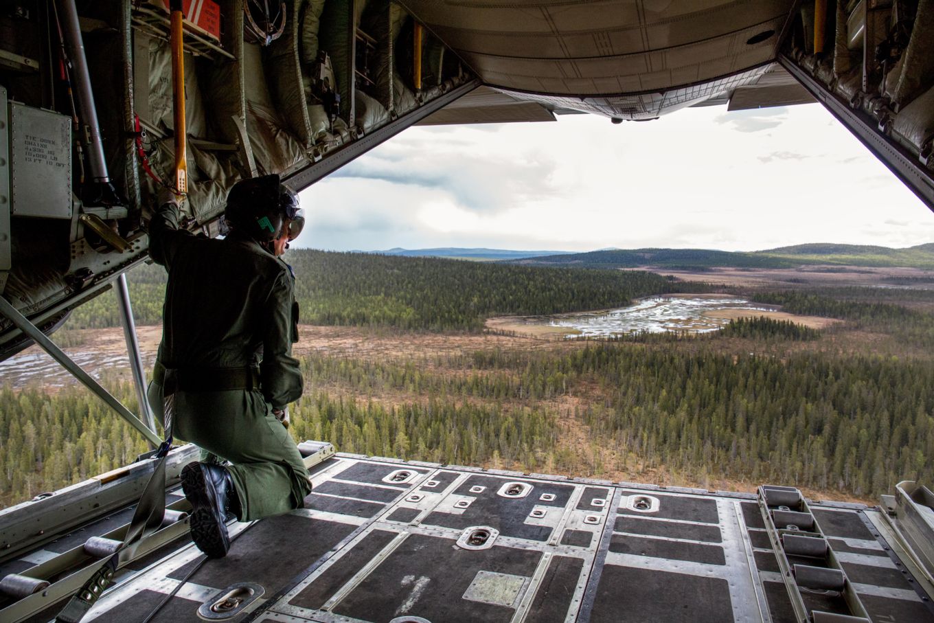 A loadmaster from 47 Squadron, based at Brize Norton, on the ramp of a C-130J Hercules performing a low-level sortie over Northern Sweden