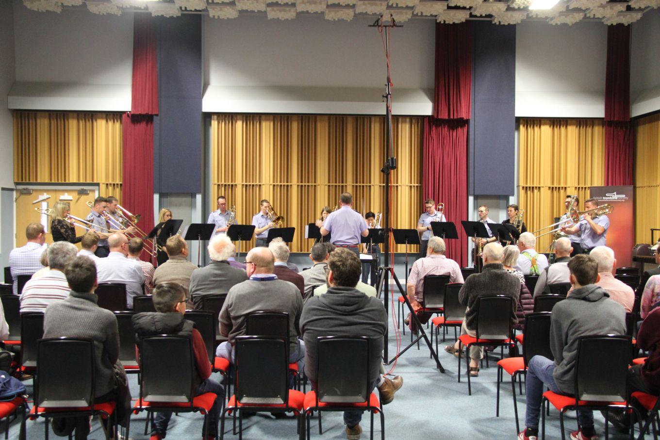 People watch a trombone ensemble play music.