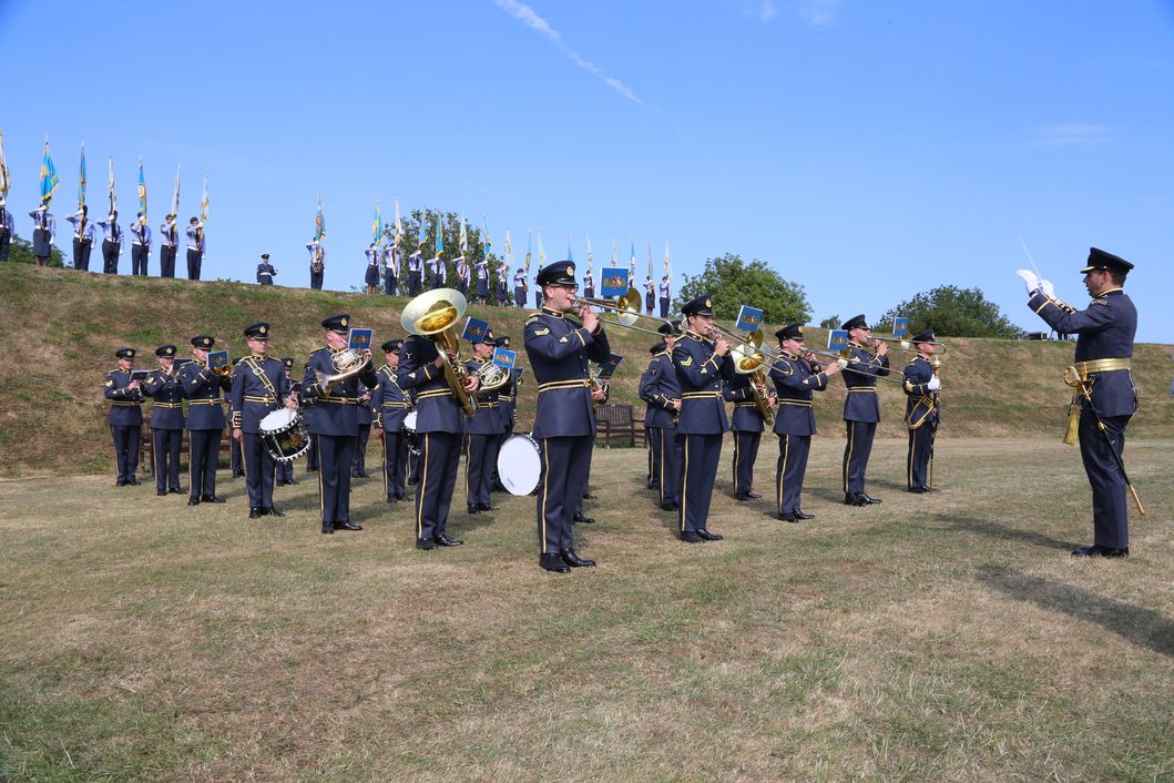 Central Band of the RAF in static parade formation play music.