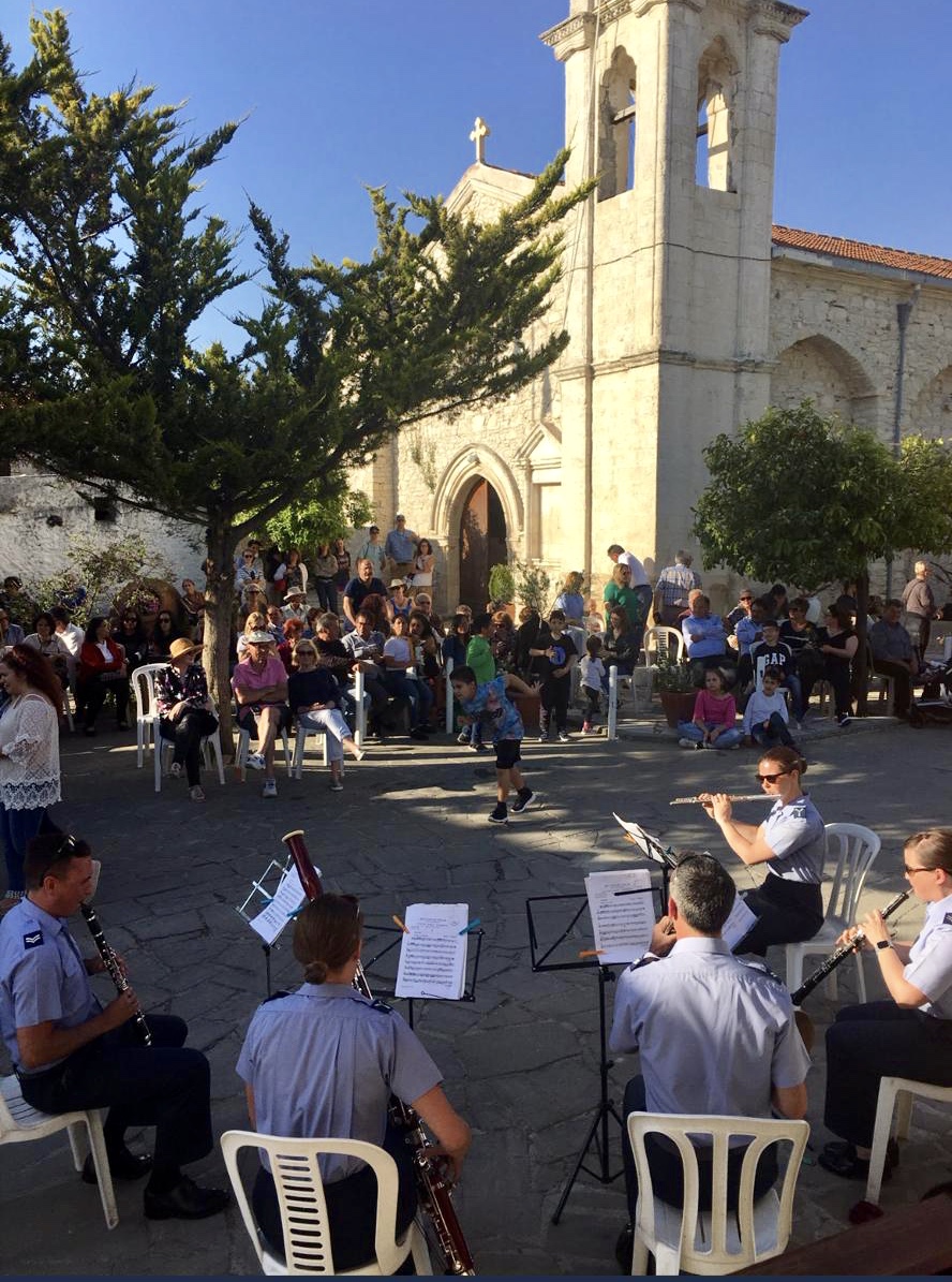 Uniformed woodwind quintet play music in a town square.