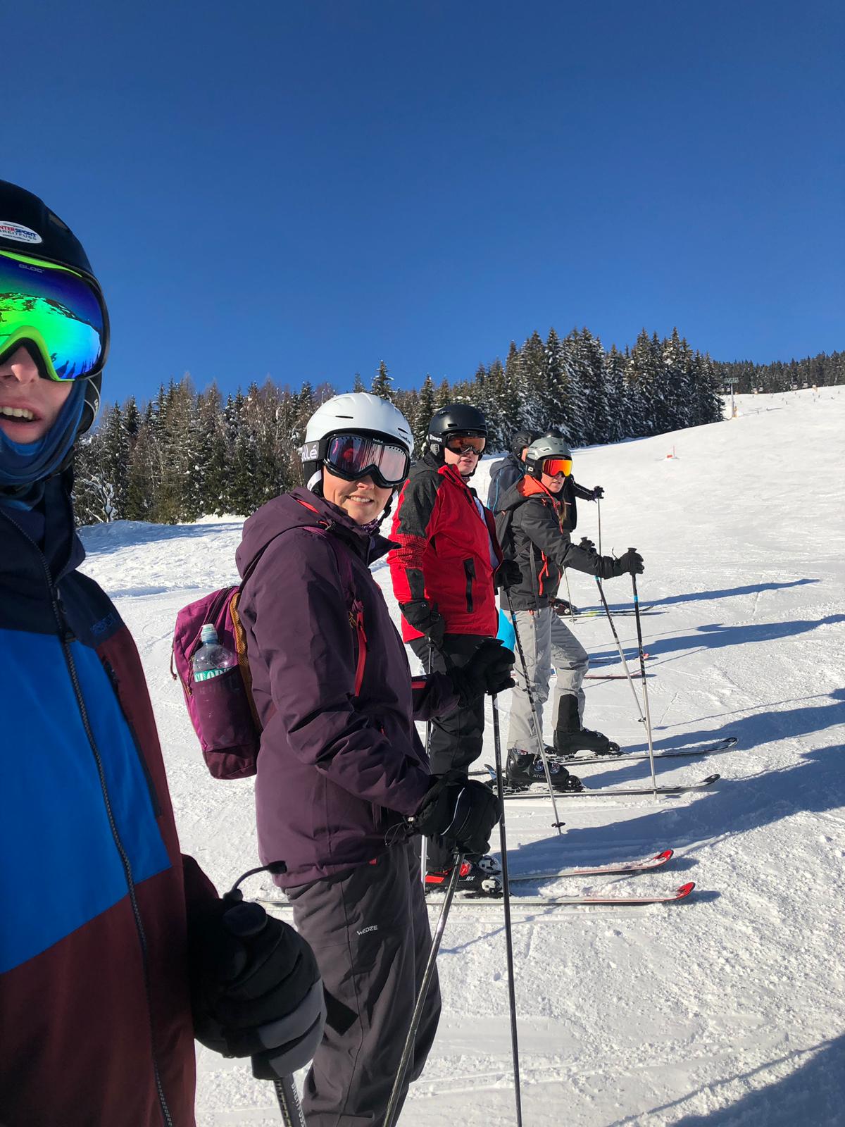 Skiers line up in the snow.