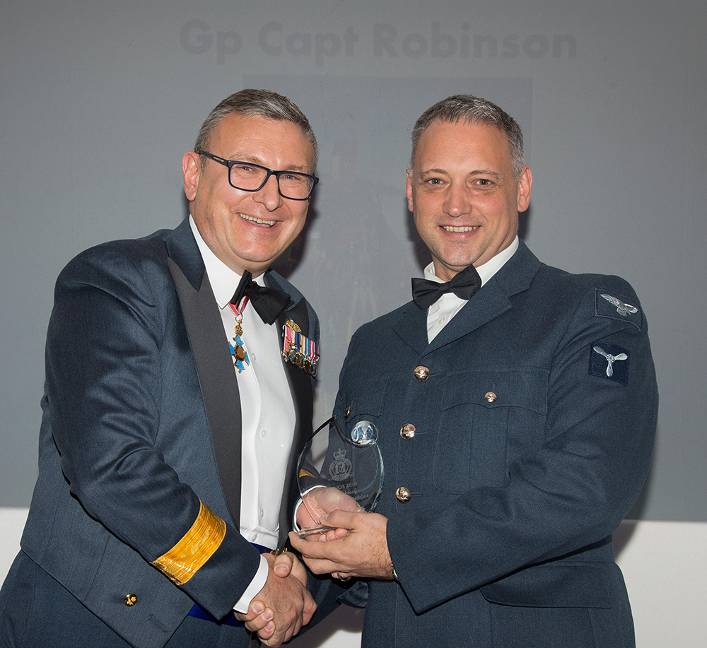 Senior Aircraftman Bisset proudly accepting the Group Captain Robinson Memorial Award from Air Mobility Force Commander, Air Commodore Domonic Stamp CBE MA RAF