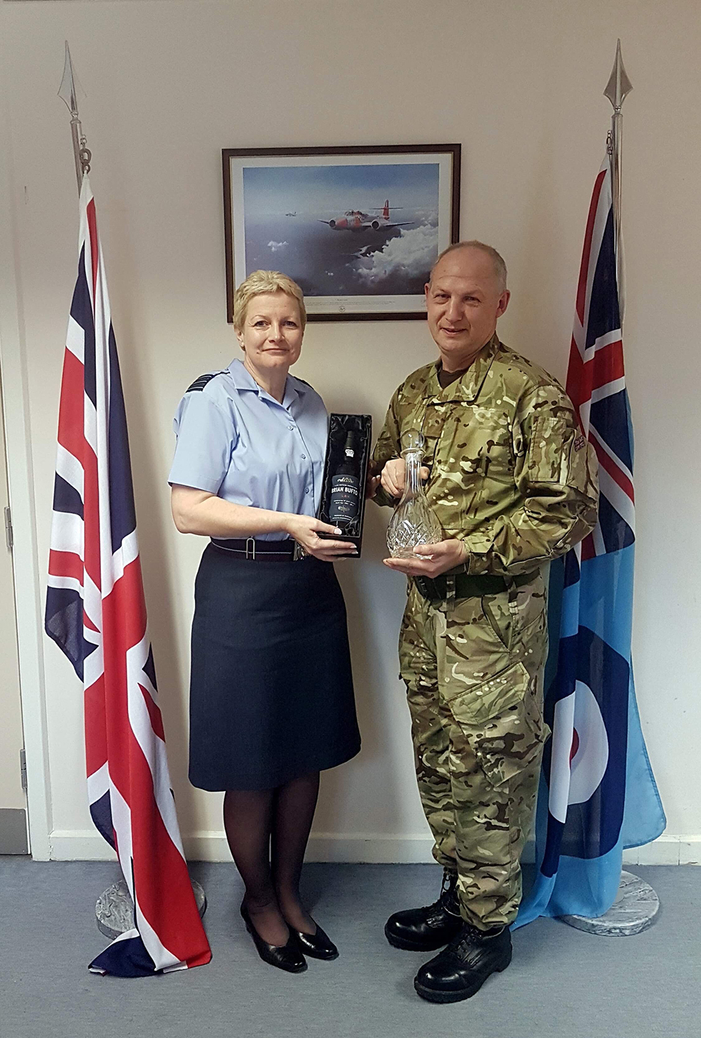 Wing Commander Bev Peart, Officer Commanding Number 4624 Squadron, presents a personalised bottle of port, a cut glass decanter and a certificate to Corporal Brian Bufton in 2017