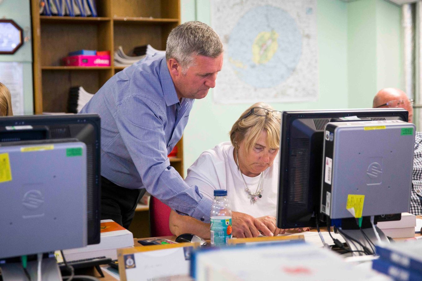 Instructor teaching a lady beside a computer