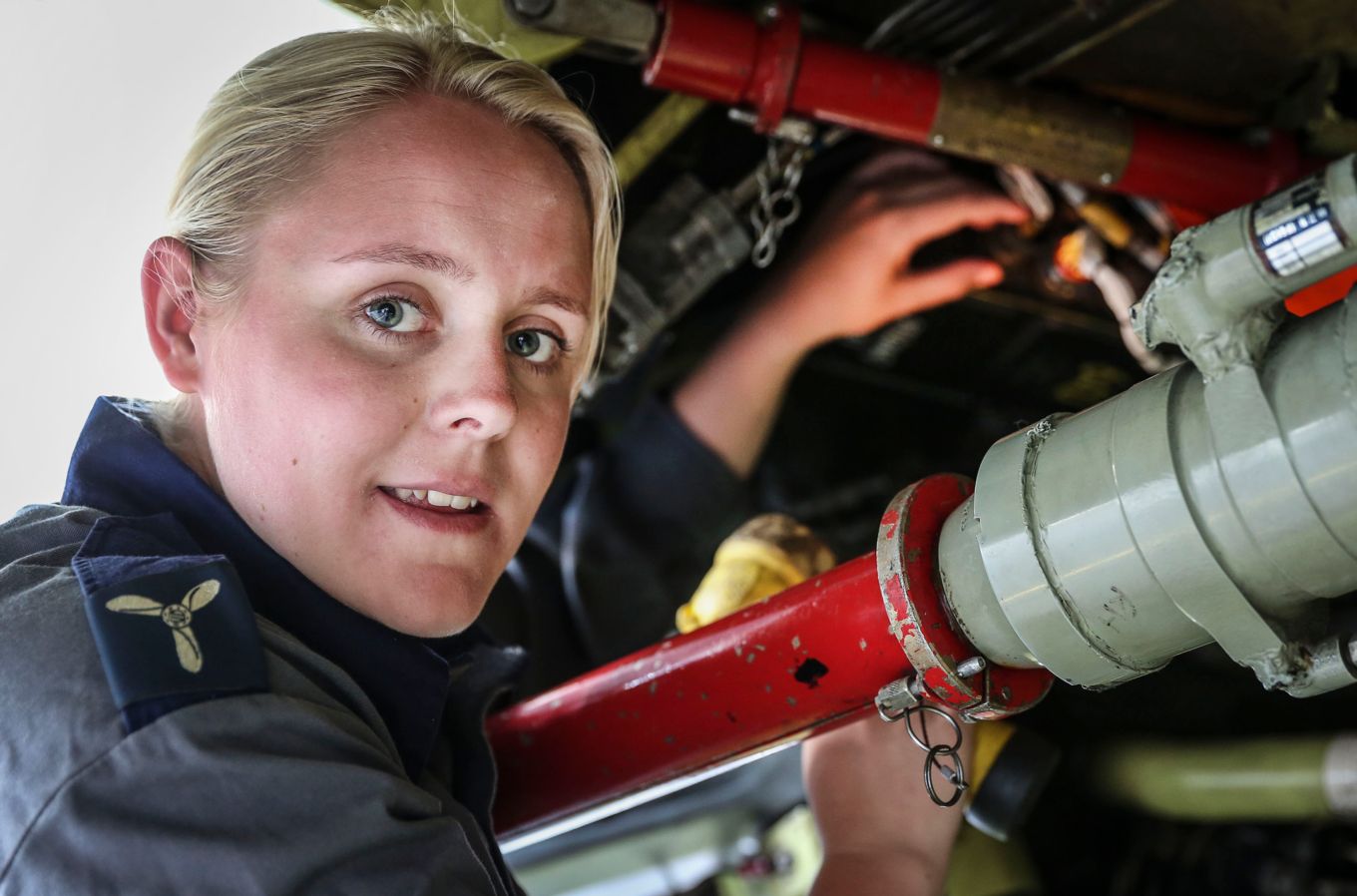 Female aircraft maintenance mechanic working on a Jaguar aircraft.