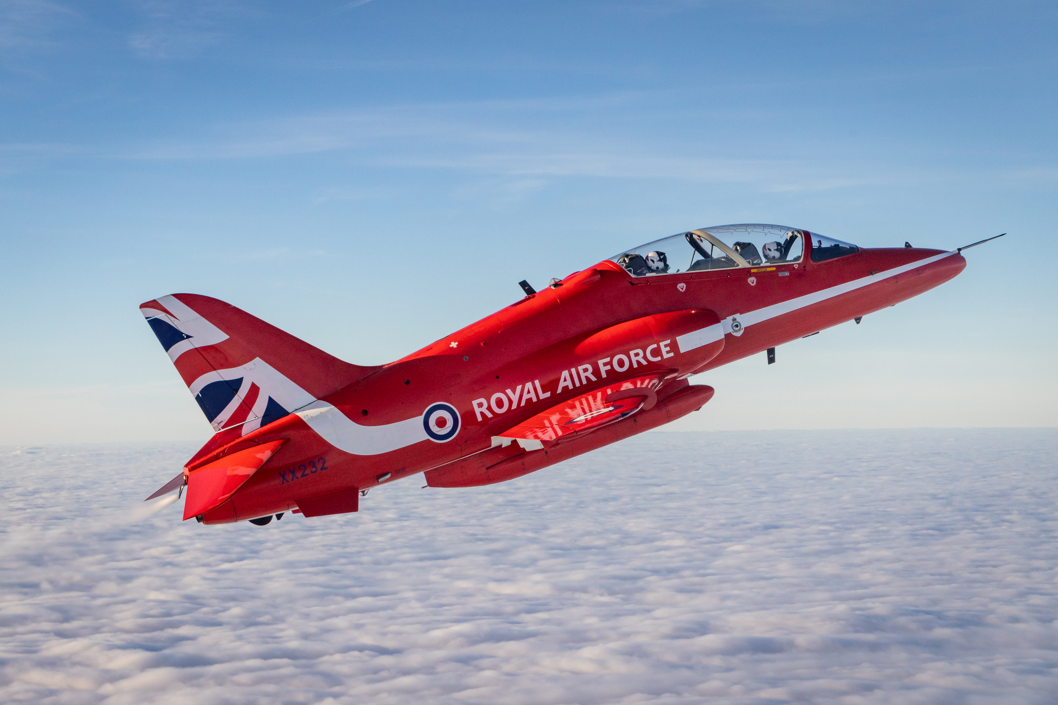 A Red Arrows jet carrying Greg James flies above the clouds.