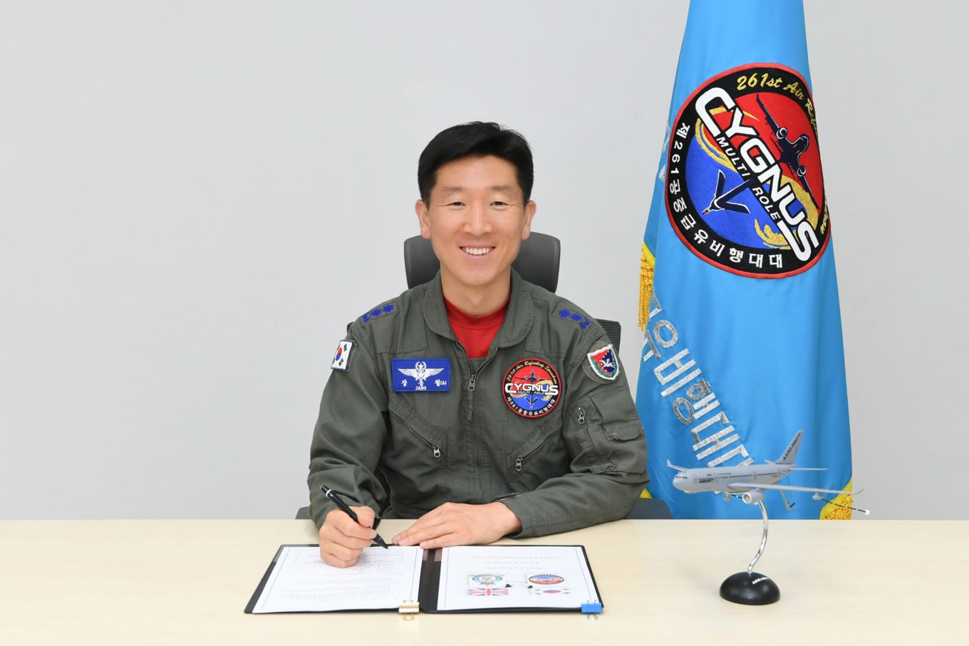 Commander Lieutenant Colonel Jang Dongchul signs the Memorandum of Understanding, with a statue of the Airbus Tanker and flag in the background.