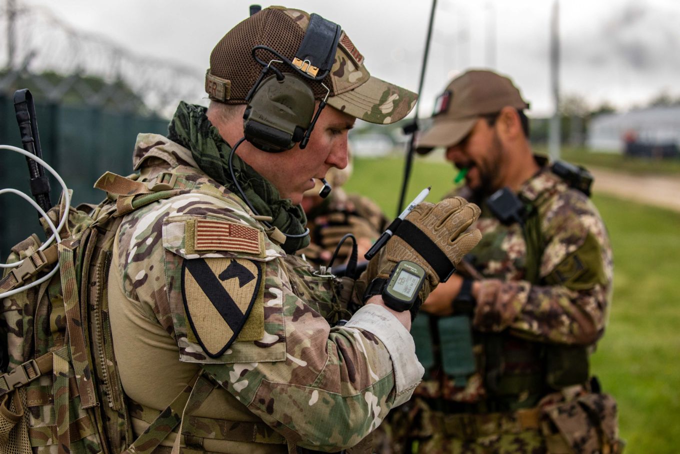 JTAC using radio while two others work in the background. .