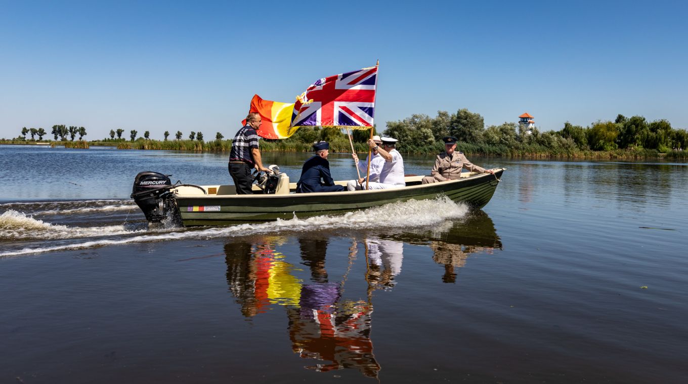 Personnel in boat with flags.