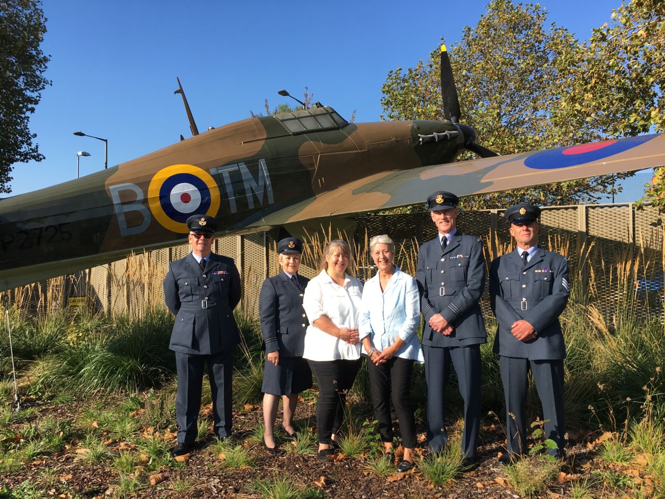 From left to right: WO David Dundas, Flt Lt Jill Harrison, Mrs Kate Whitworth (daughter of Ray Holmes), Mrs Anne Holmes, Sqn Ldr Andy Ham, Sgt Nick Woolmer with the Hurricane gate guardian at the RAF Museum in Hendon.