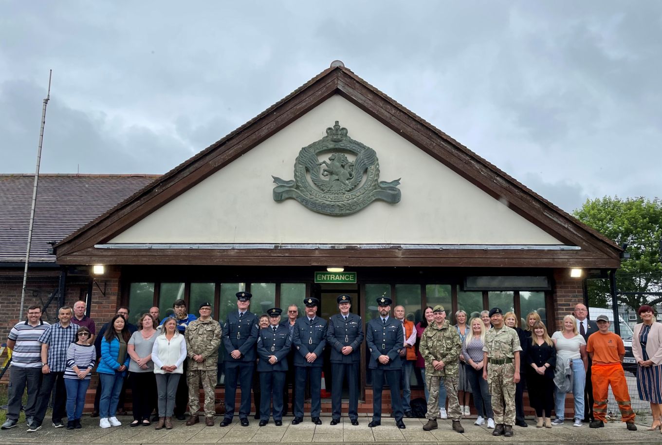 Personnel standing under the RAF Manston Station Crest. 