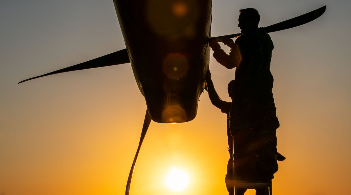 Ground team maintain section of a C-130J Hercules.