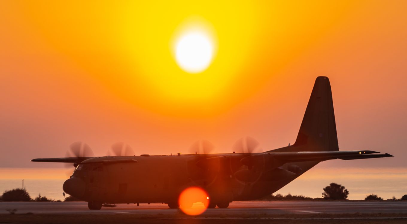 C-130J Hercules aircraft amid sunset.