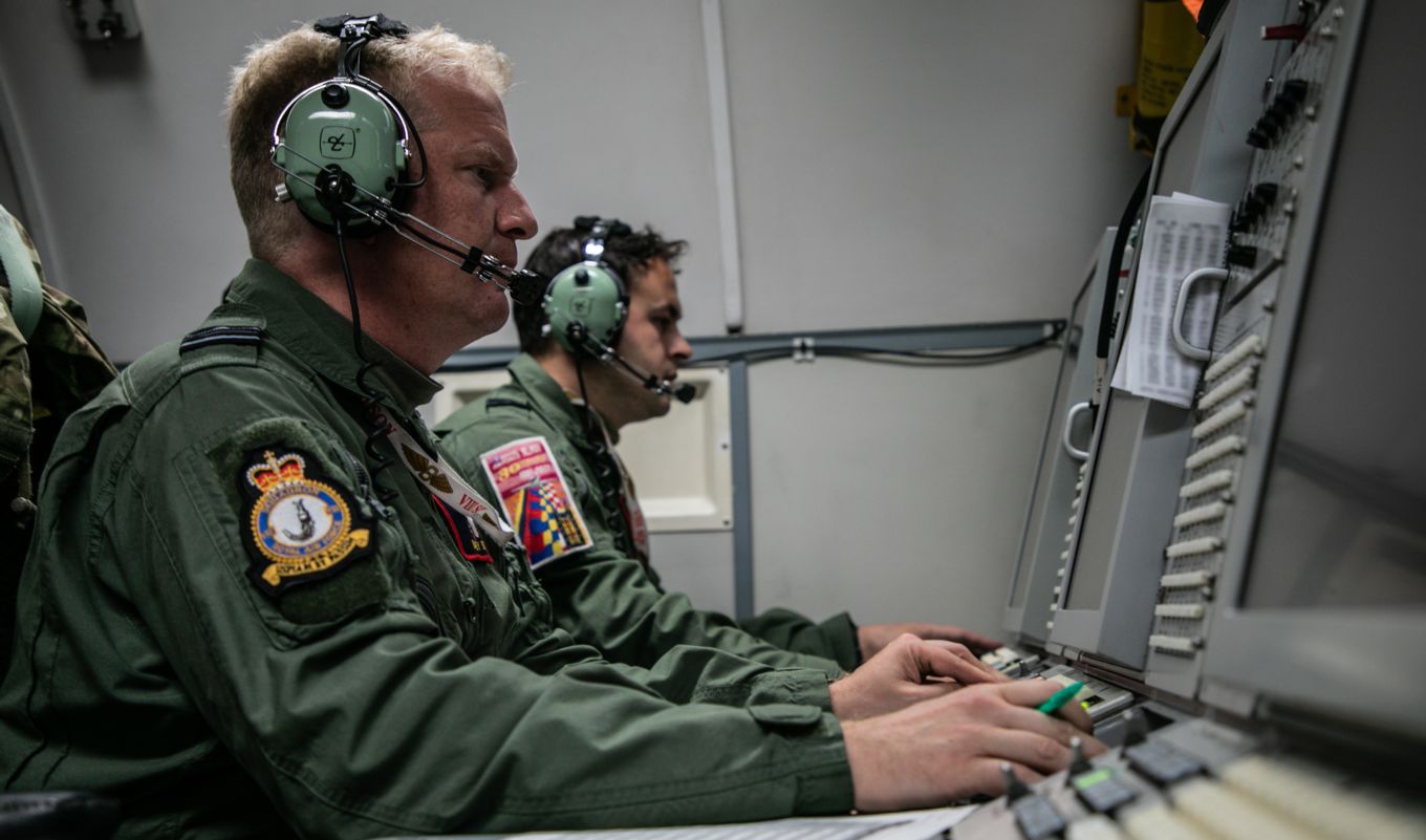 Personnel with headset operate the cockpit.