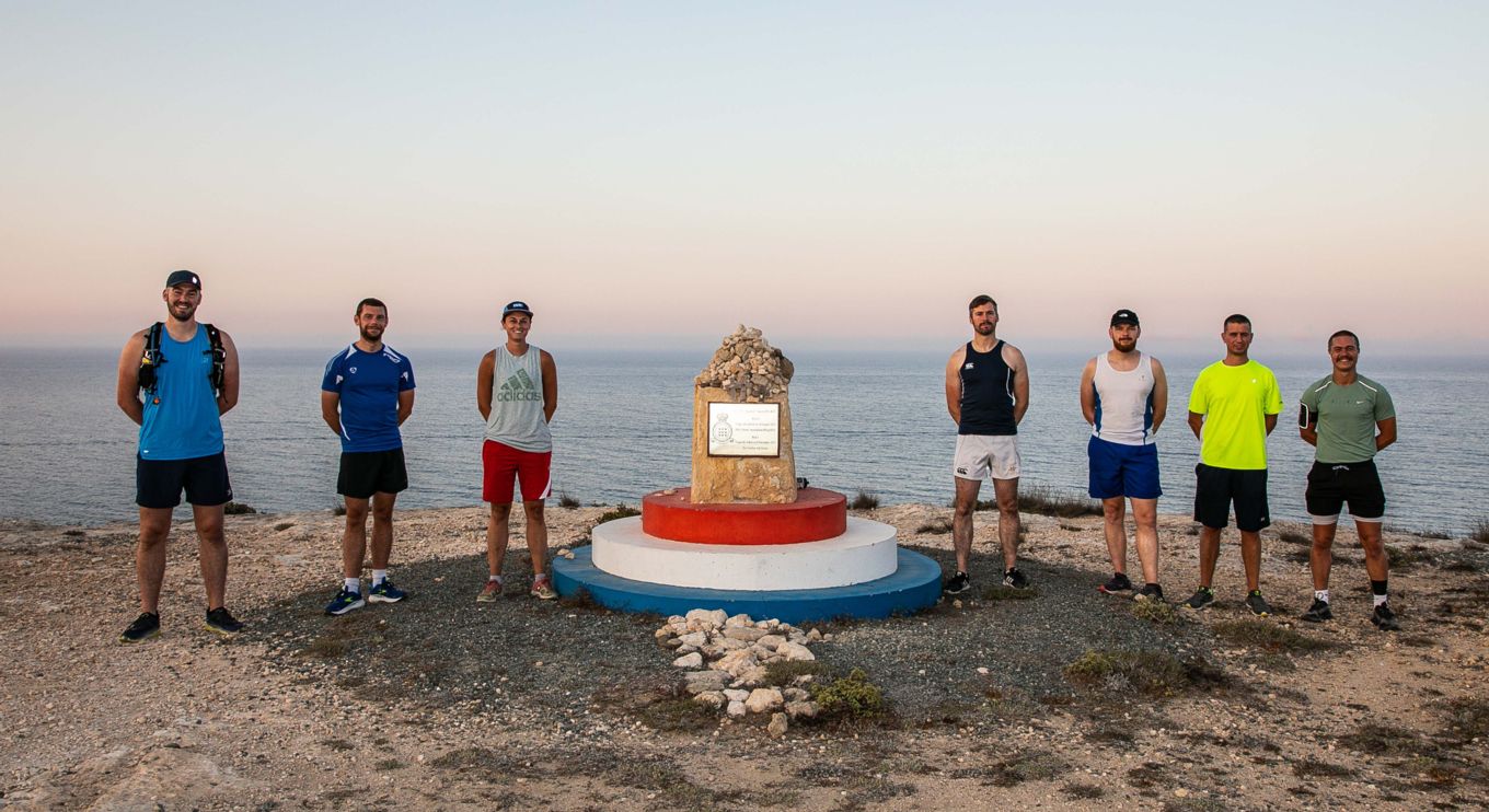 The runners stand by the Jon Egging memorial.