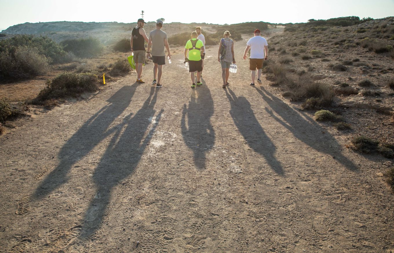 The runners on the trail with shadows casting back.