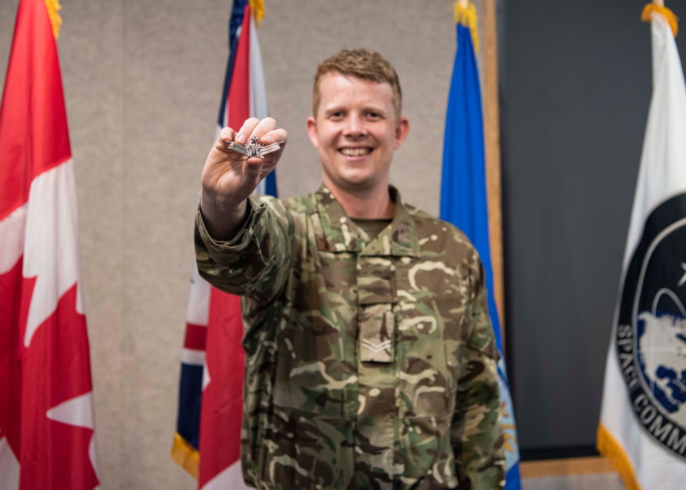 Image shows Corporal Mitchell Astbury holding his new badge