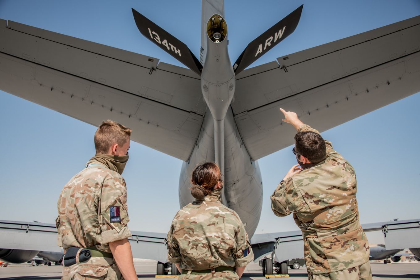 Image shows RAF and US Air Force personnel looking at the rear of an aircraft.