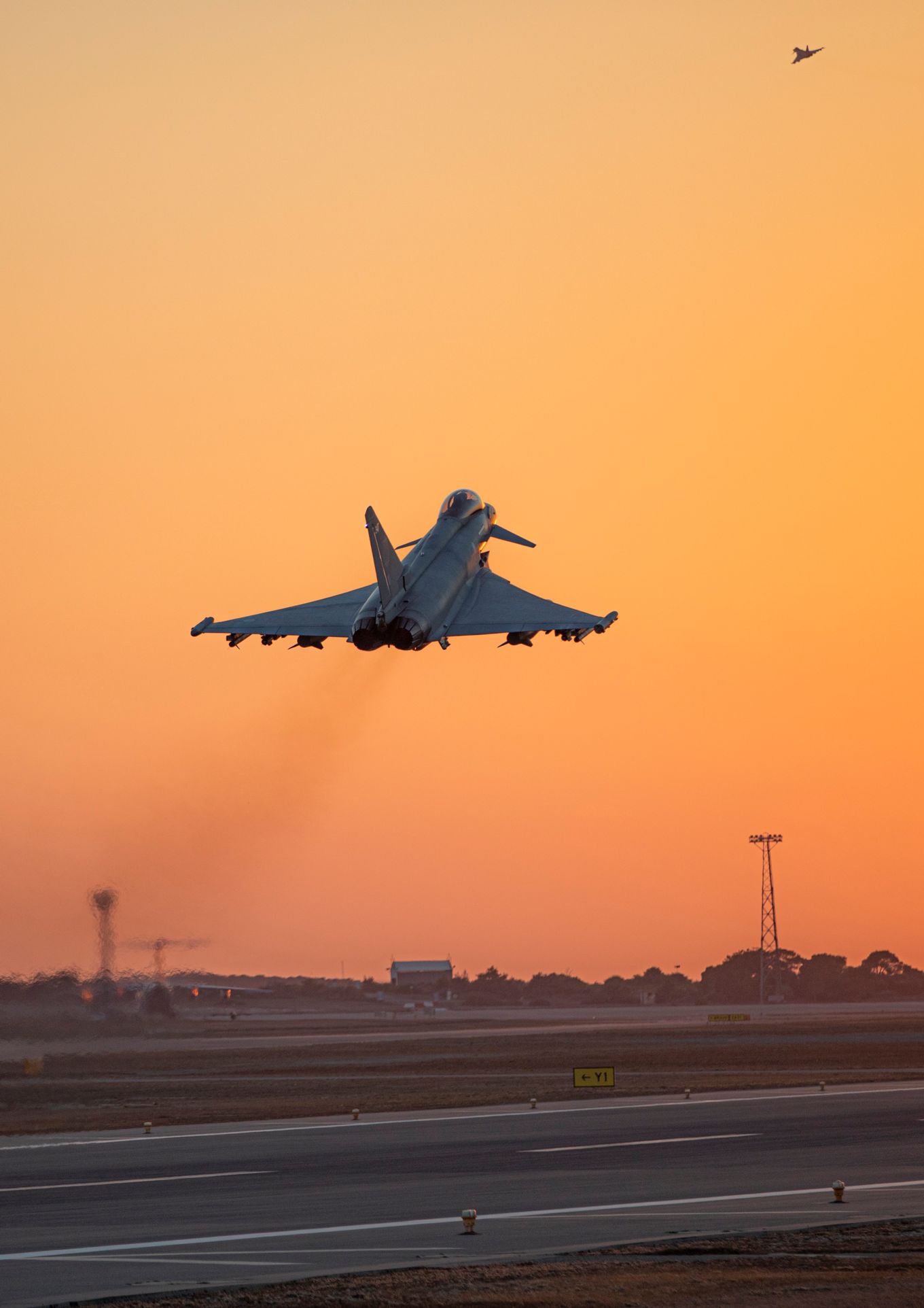 Image shows an RAF Typhoon taking off at sunset.